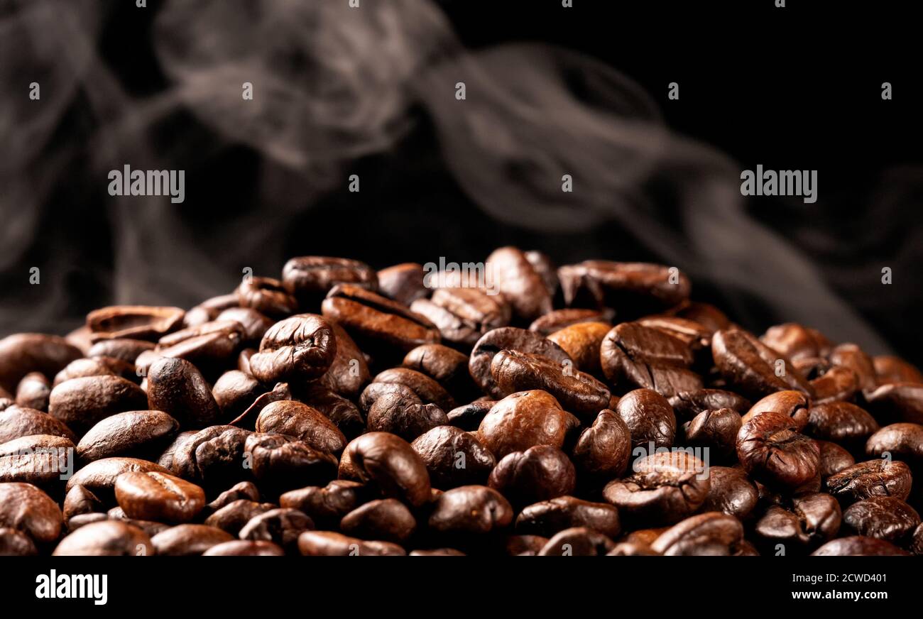 Freshly roasted coffee beans with smoke Stock Photo - Alamy