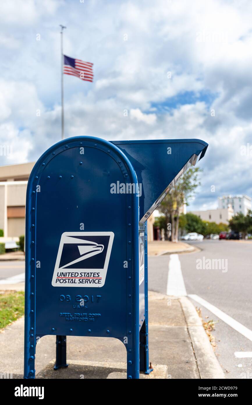 Hattiesburg, MS / USA - September 17, 2020: United States Postal Service collection box with flag in background, in downtown Hattiesburg, MS Stock Photo