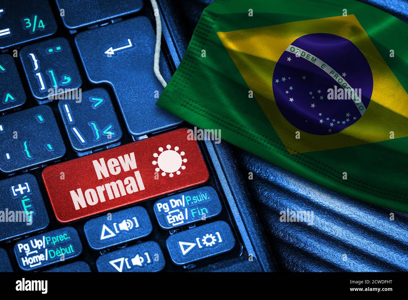 Concept of New Normal in Brazil during Covid-19 with computer keyboard red button text and face mask showing Brazilian Flag. Stock Photo