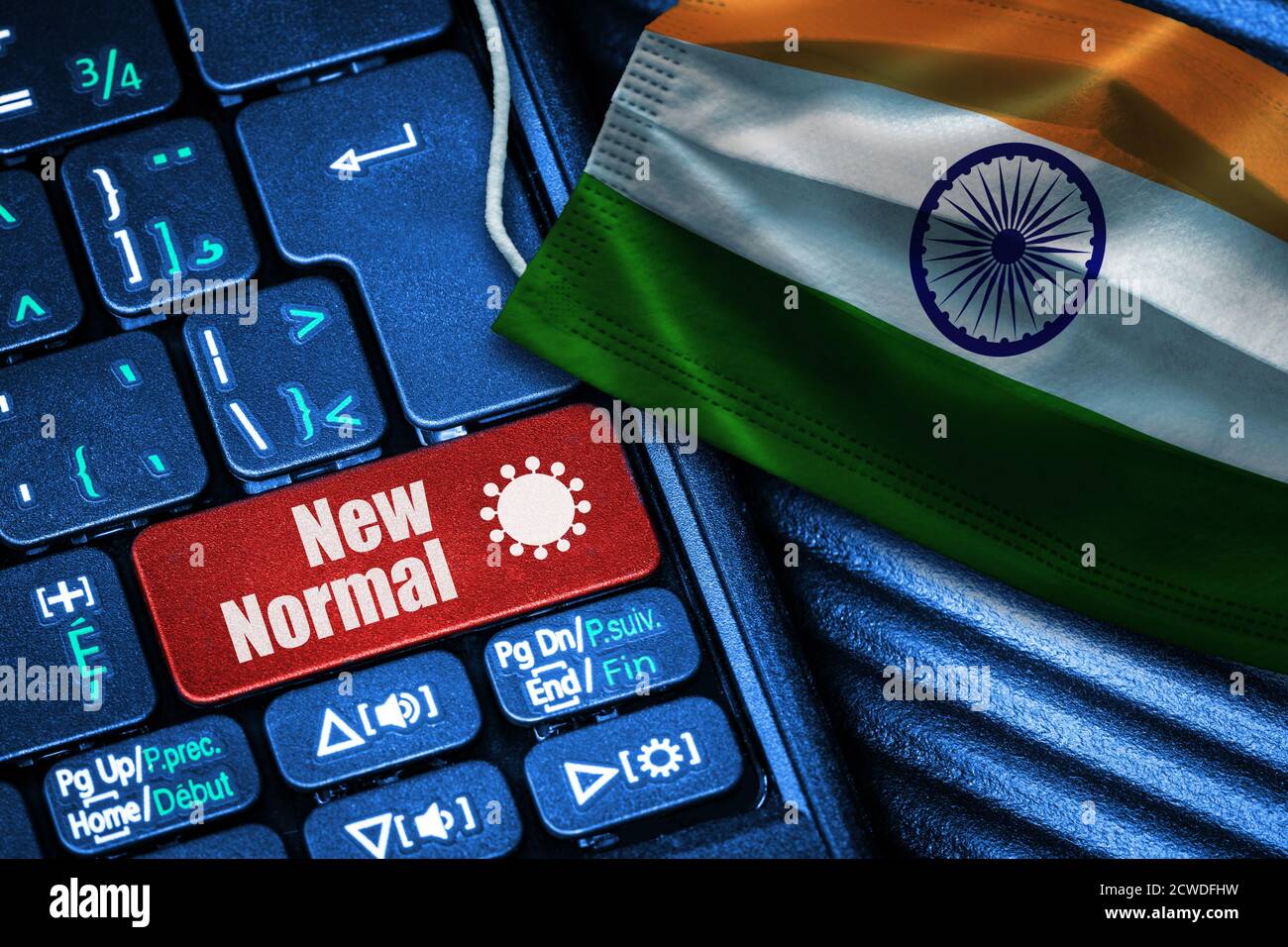 Concept of New Normal in India during Covid-19 with computer keyboard red button text and face mask showing Indian Flag. Stock Photo