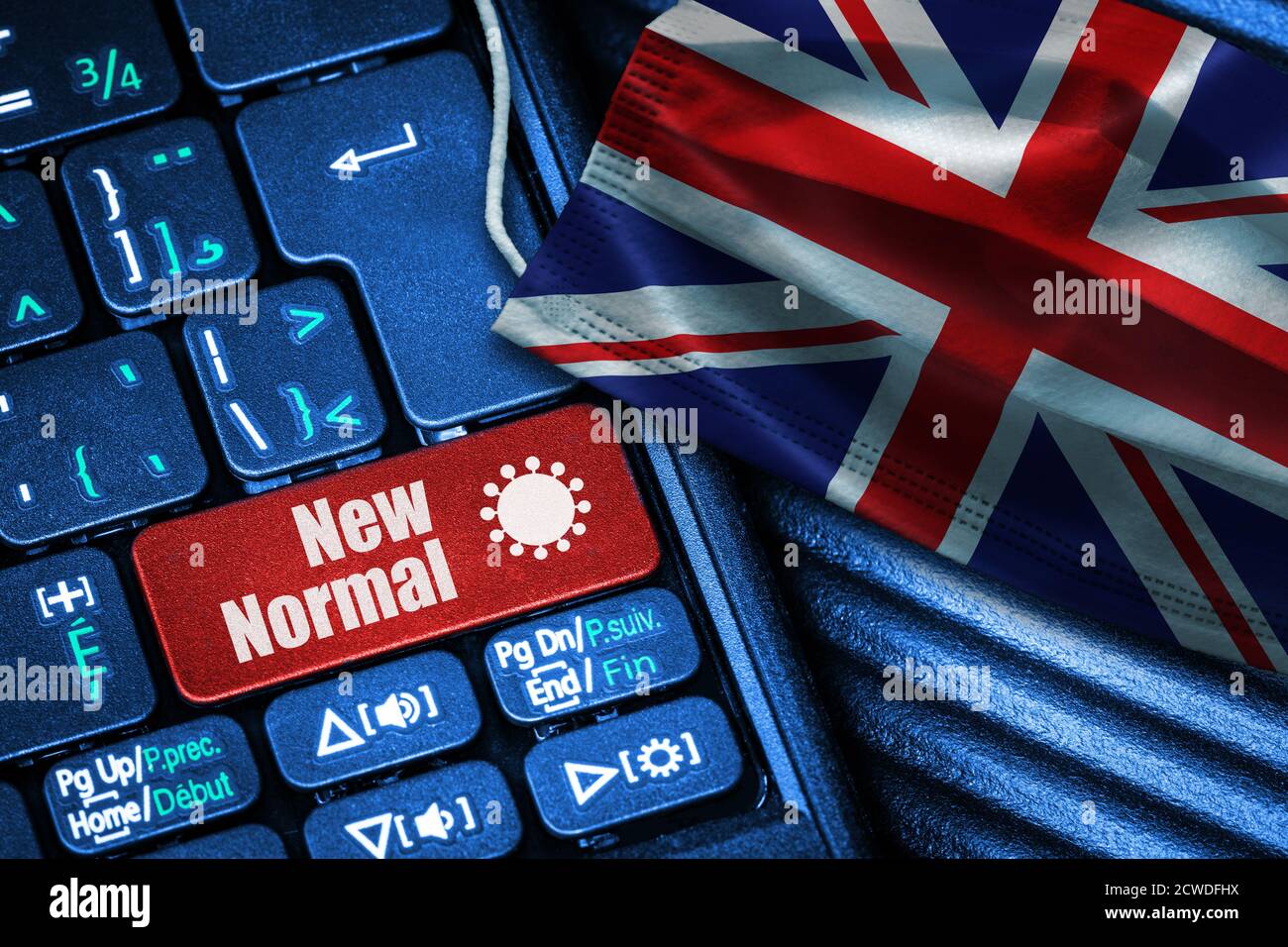 Concept of New Normal in United Kingdom during Covid-19 with computer keyboard red button text and face mask showing UK Flag. Stock Photo