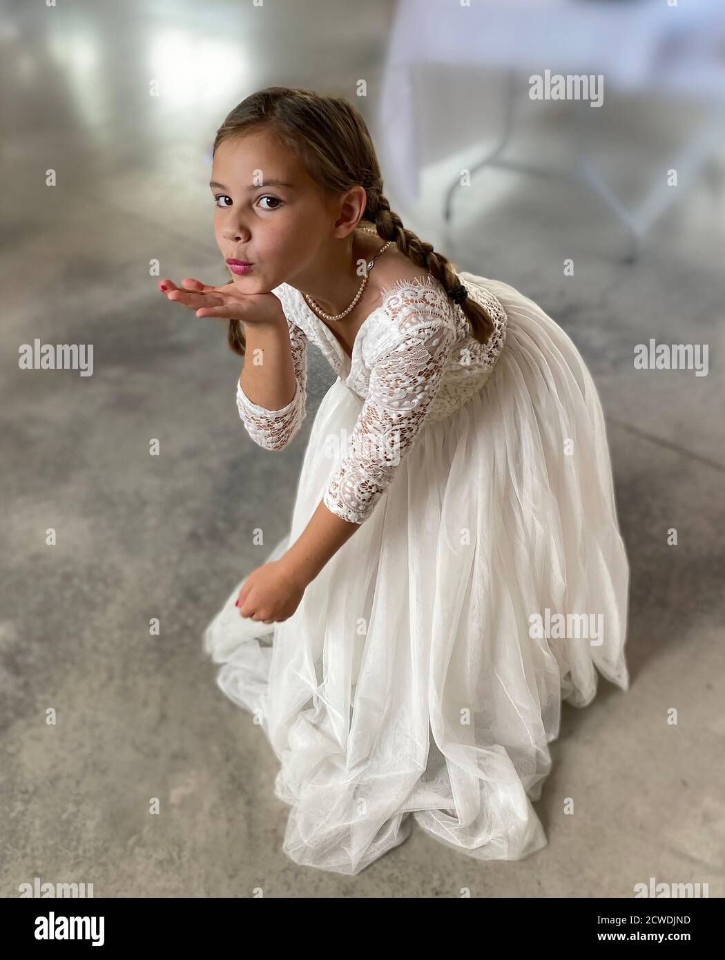 Portrait of a seven year old girl dressed up in a flower girl or communion dress Stock Photo