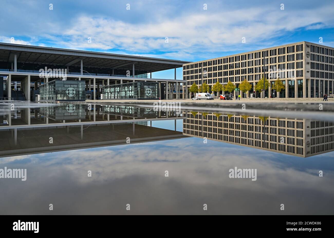 29 September 2020, Brandenburg, Schönefeld: The main terminal (l) and an outbuilding of Berlin Brandenburg Airport 'Willy Brandt' (BER) are reflected in the water of a fountain. The capital city airport BER on the border to Berlin is scheduled to open on 31.10.2020. Photo: Patrick Pleul/dpa-Zentralbild/dpa Stock Photo