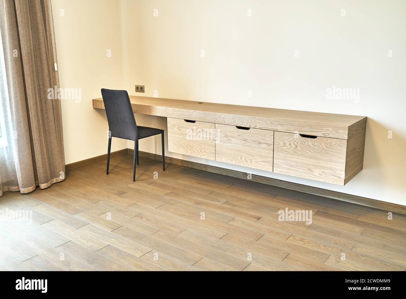 Modern furniture. Wall mounted wooden dressing table wiht drawers in  contemporary bedroom Stock Photo - Alamy