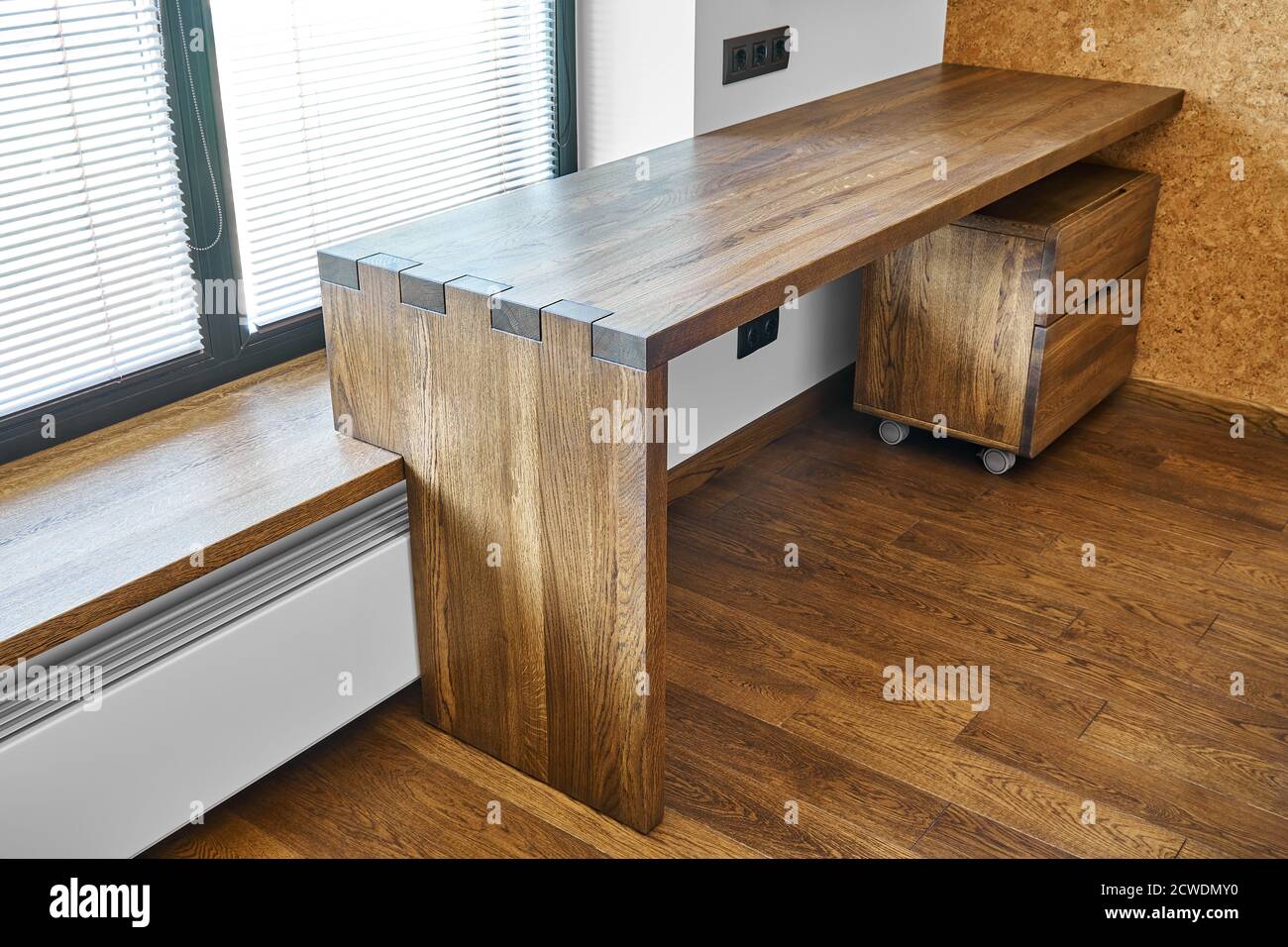 Modern furniture. Box joint solid wooden console desk against the background of the window Stock Photo