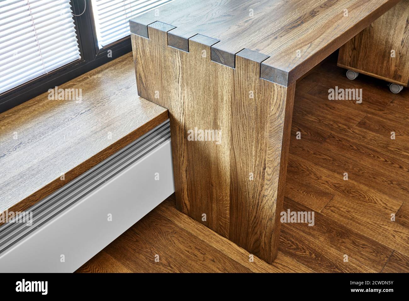 Modern furniture. Box joint solid wooden console desk against the background of the window Stock Photo