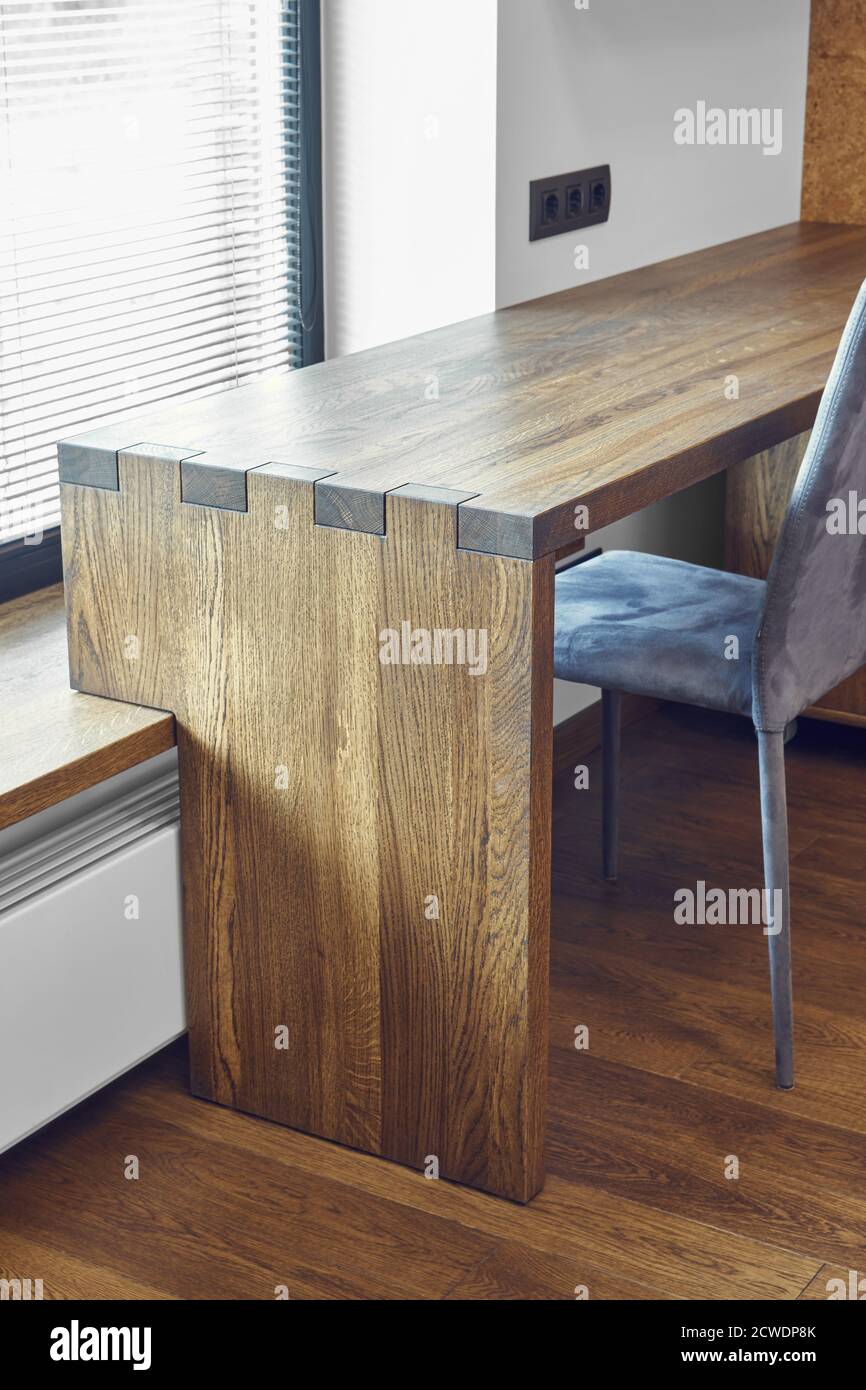 Modern furniture. Box joint solid wooden console desk against the background of the window Stock Photo