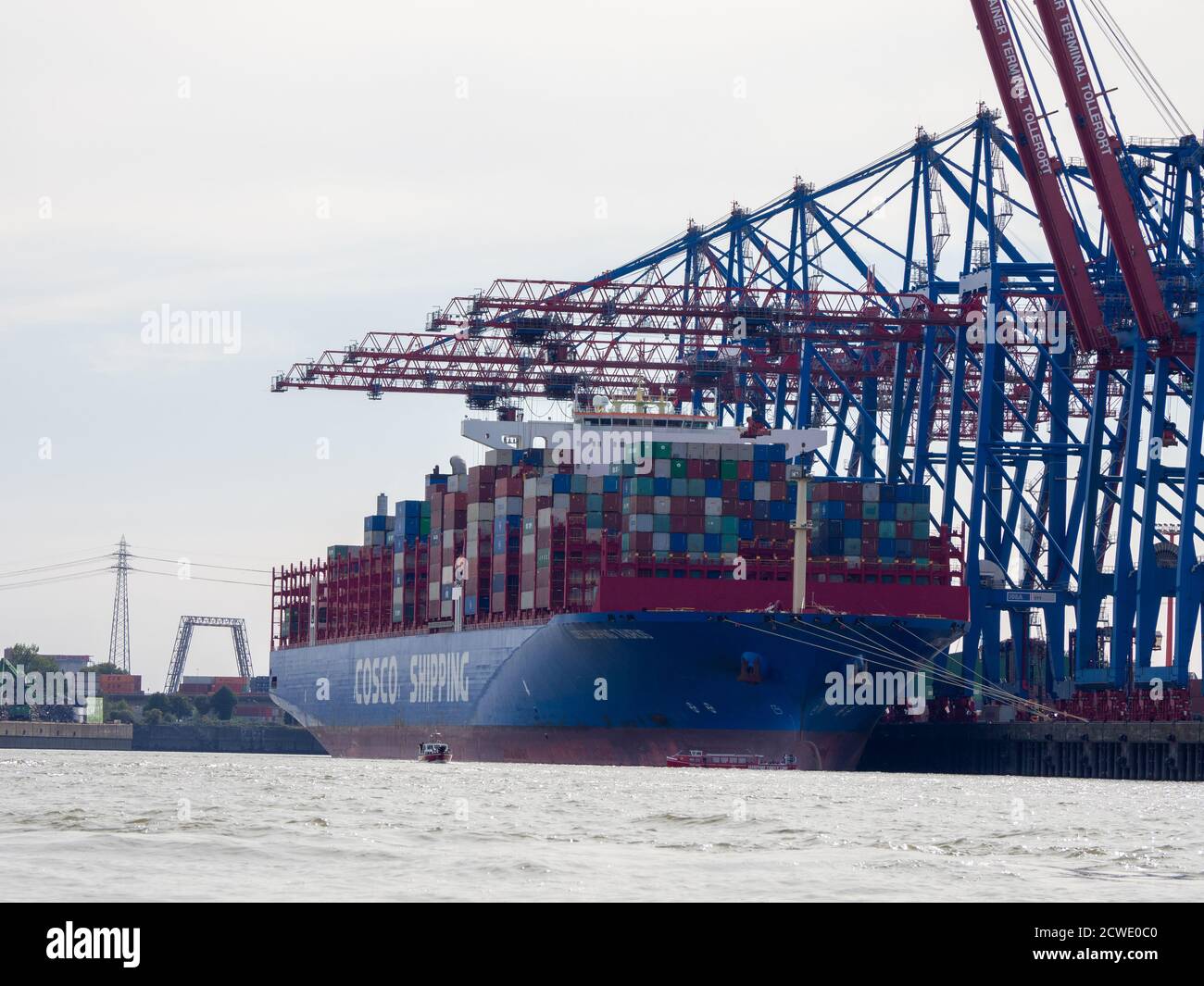in the port of Hamburg there is a huge blue container ship loaded with ...