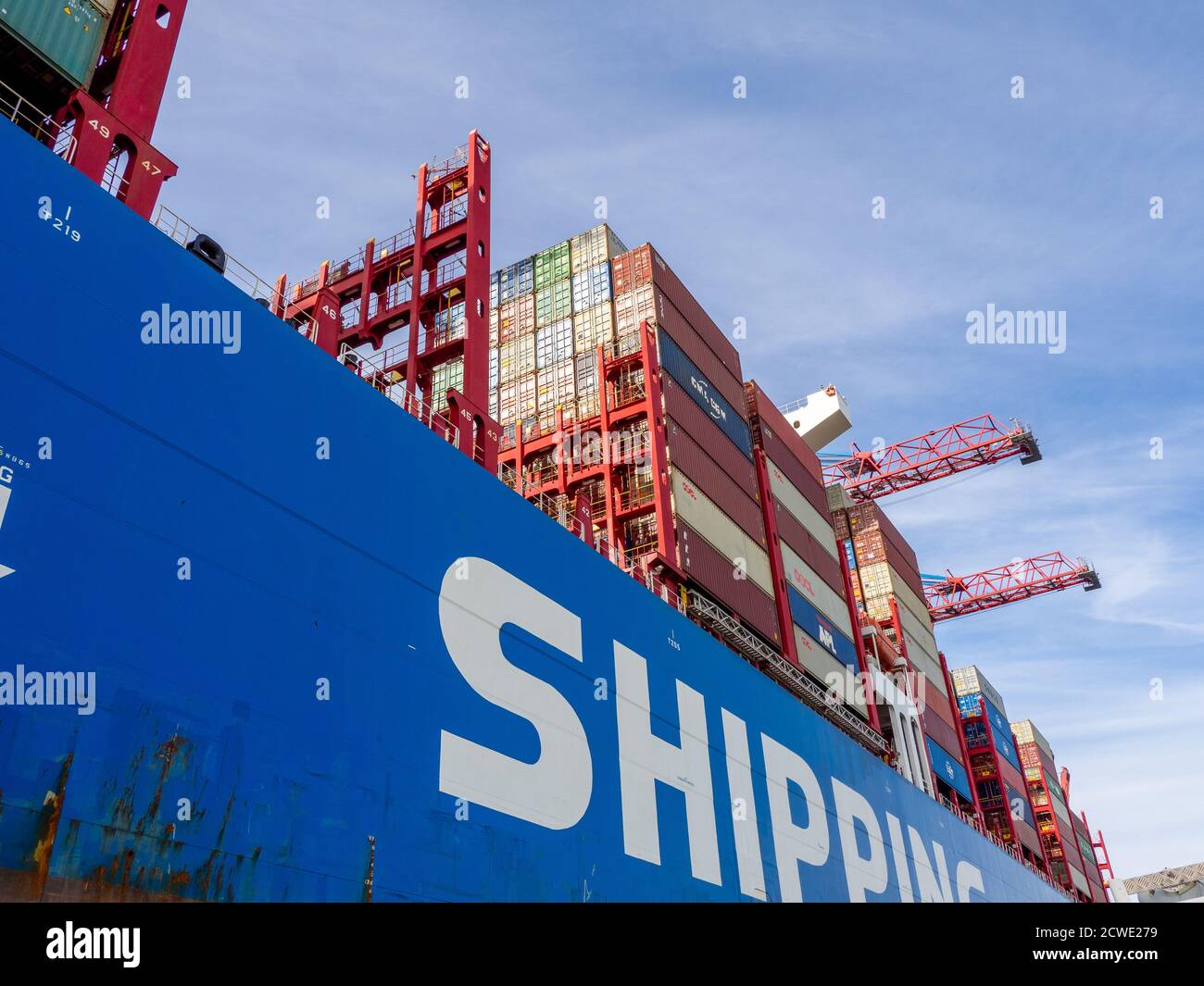 in the port of Hamburg there is a huge blue container ship loaded with ...