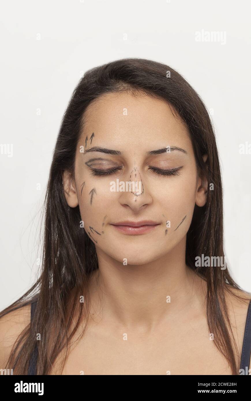Vertical shot of surgical lines on a beautiful woman's face isolated on