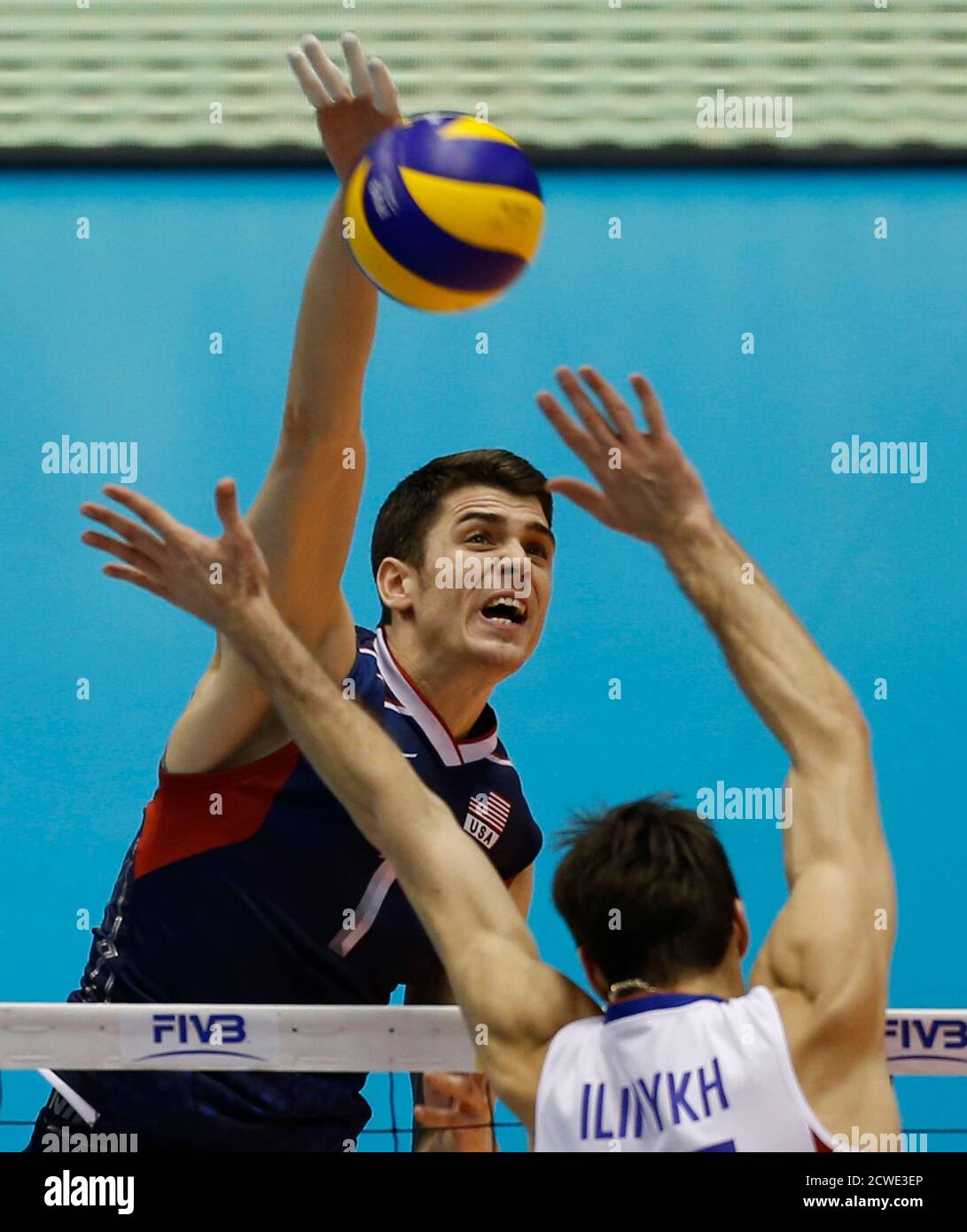 Matthew Anderson of the U.S. spikes the ball against Dmitriy Ilinykh of  Russia on the final day of their FIVB Men's Volleyball World Grand  Champions Cup 2013 in Tokyo November 24, 2013.