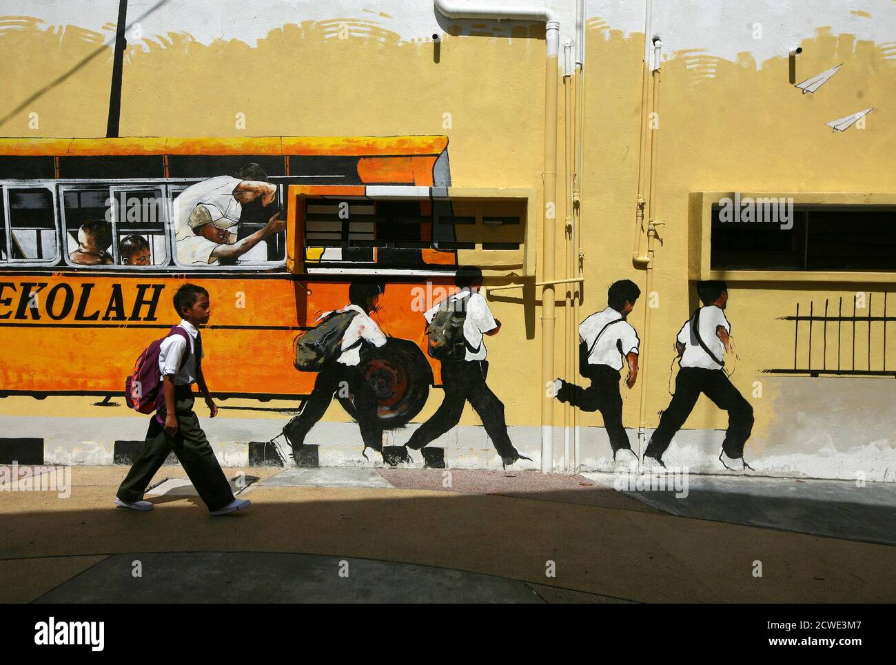 A School Boy Walks Past A Street Mural Depicting A School Bus And Students In Shah Alam Outside Kuala Lumpur January 2 2014 Malaysia Begins The First Day Of The New School