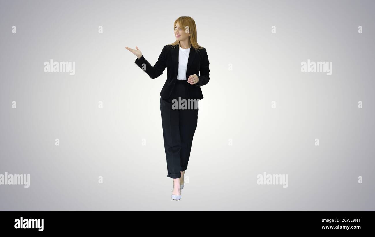 Female presenter blond woman walking and pointing to the sides o Stock Photo