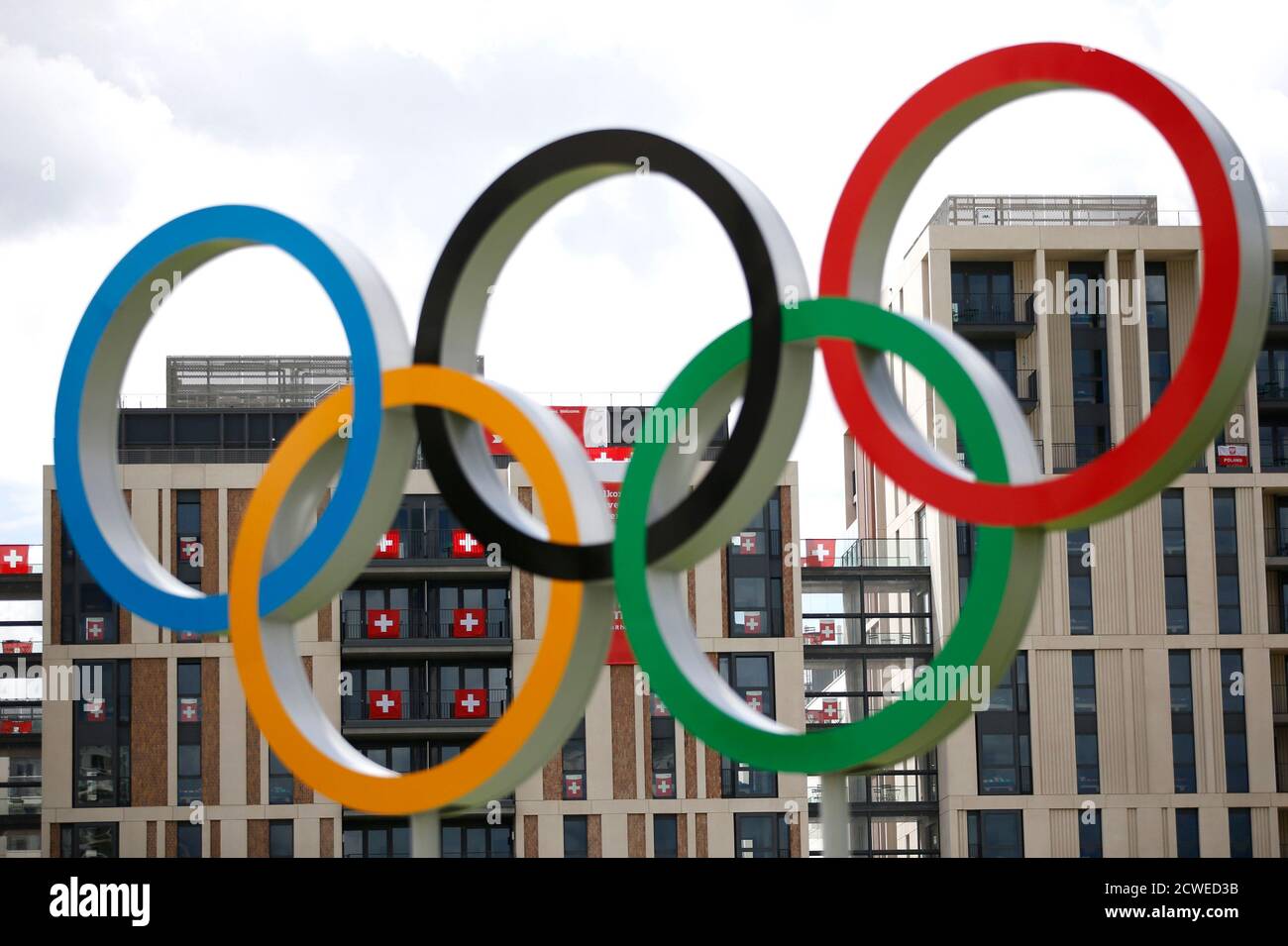 Swiss flags are visible through the Olympic rings the Athletes' Village at the Olympic Park in London, July 19, 2012.  REUTERS/Jae C. Hong/Pool (BRITAIN - Tags: SPORT OLYMPICS) Stock Photo