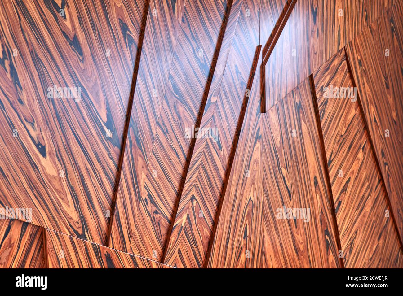 3D wood wall panels. Wood veneer wall panels elements are covered with dust. Rosewood reconstituted veneer. Furniture manufacturing. Closeup Stock Photo