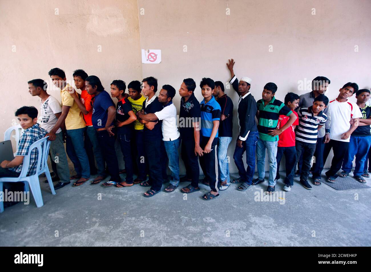 Rohingya men stand in a line at a centre to register for a 