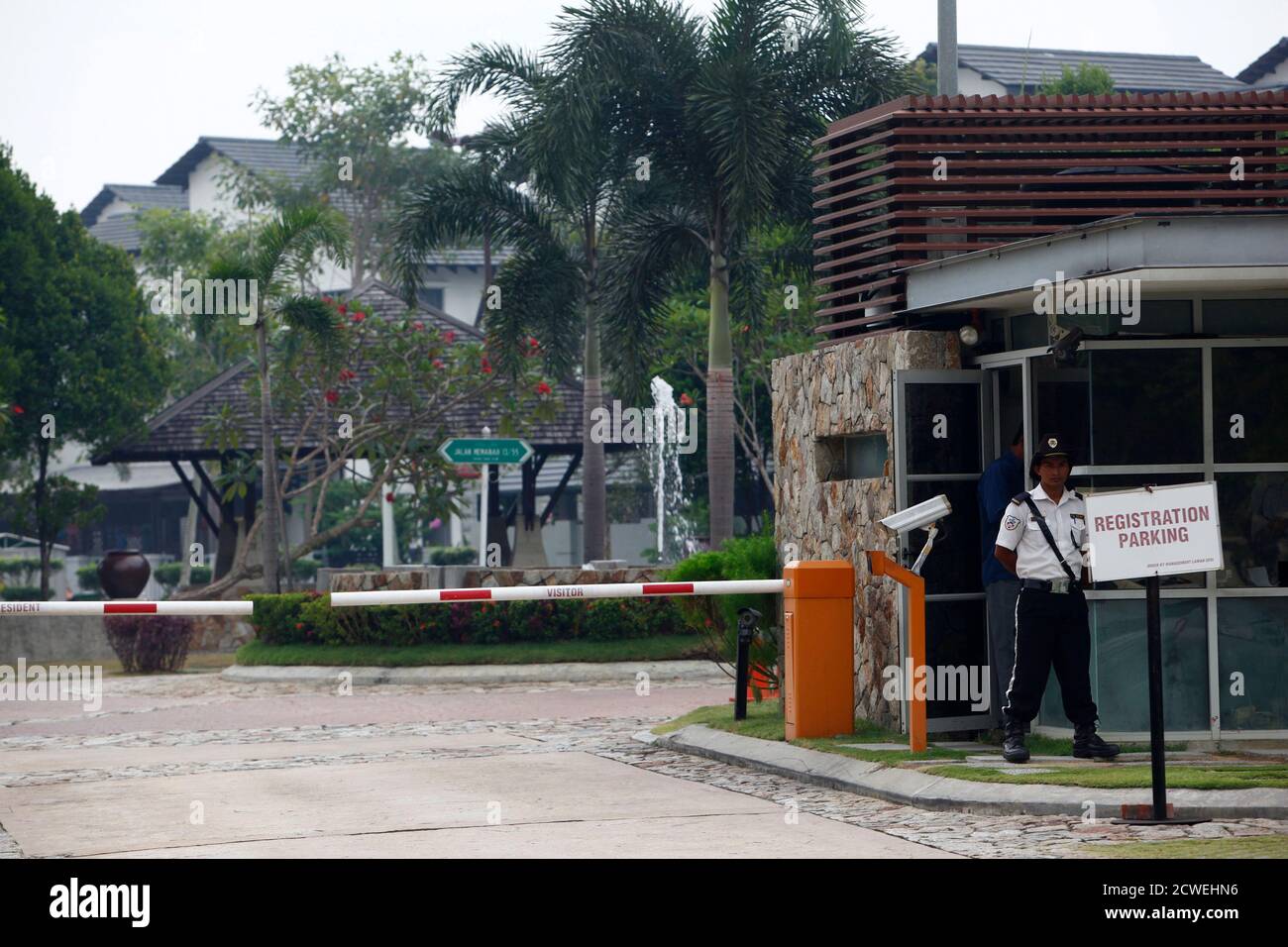 A Security Guard Stands At The Entrance Of A Compound Where The House Of Pilot Zaharie Ahmad Shah Is Located In Shah Alam Near Kuala Lumpur March 15 2014 Police Began Searching
