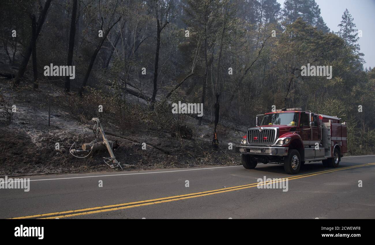 Angwin, United States. 29th Sep, 2020. A fire engine pases a burning high volltage power pole beside the road in Angwin, California on Tuesday, September 29, 2020. The Glass Fire has burned over 40,000 acres and is only 2% contained. Photo by Terry Schmitt/UPI Credit: UPI/Alamy Live News Stock Photo