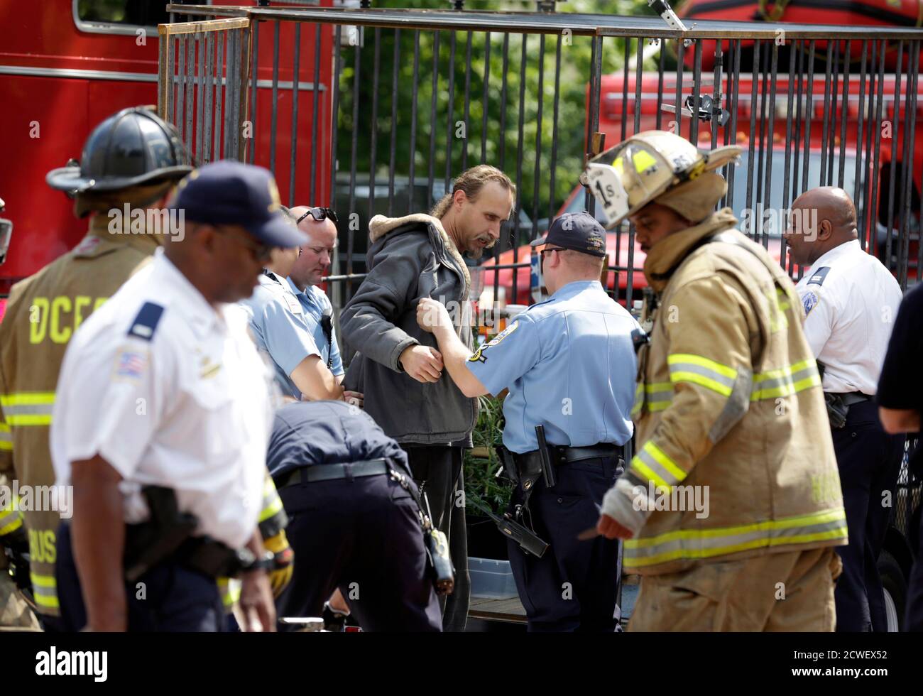 Police arrest David Bronner (C) after firefighters had to cut him out of a steel cage from which he staged a protest in front of the White House in Washington June 11, 2012. Bronner was protesting federal policy that prevents U.S. farmers from growing industrial hemp. REUTERS/Kevin Lamarque  (UNITED STATES - Tags: CRIME LAW CIVIL UNREST) Stock Photo