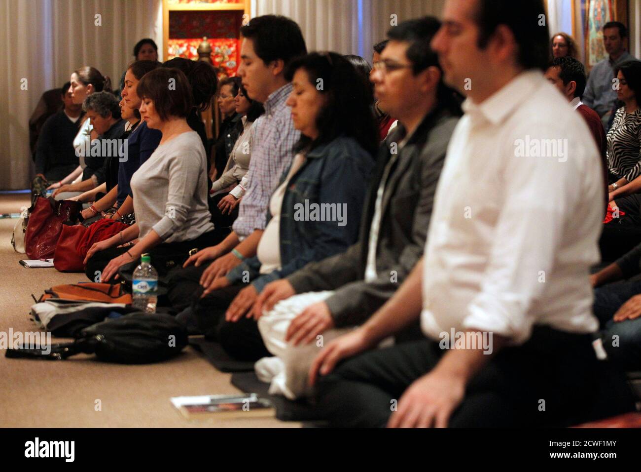 Mexican students of Tibetan Buddhist culture meditate inside Tibet house in Mexico City, October 7, 2013. The Dalai Lama will visit Mexico from October 11 to 16. Picture taken October 7, 2013. REUTERS/Edgard Garrido (MEXICO - Tags: RELIGION ) Stock Photo