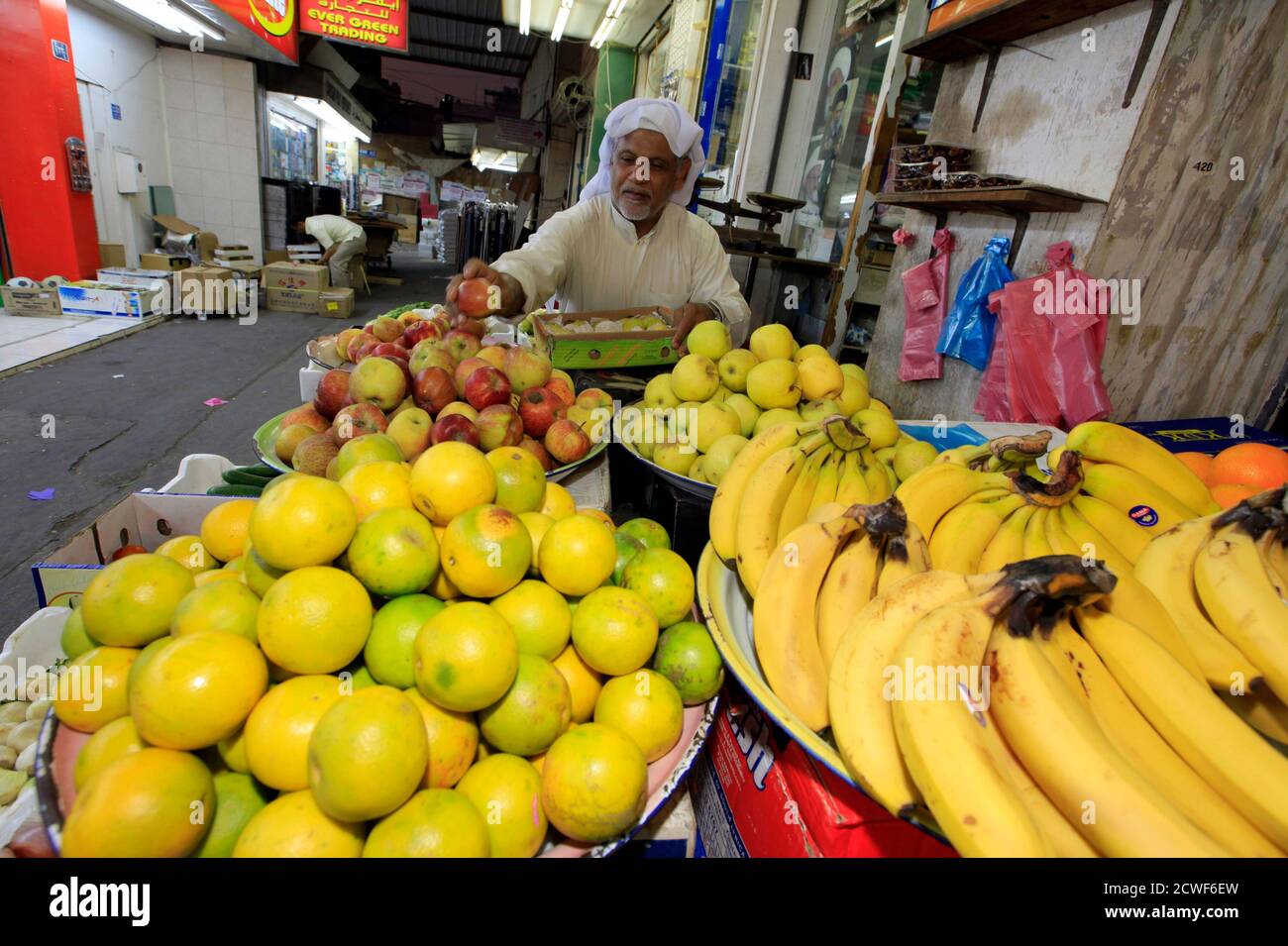 A vendor arranges fruit outside his shop in the Bahrain capital of