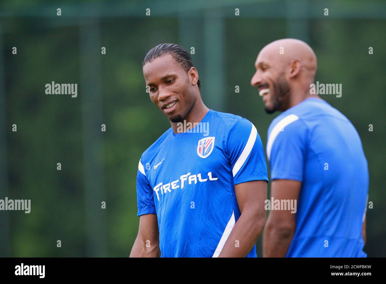 Shanghai Shenhua's Nicolas Anelka of France and his team mate Didier Drogba (L) of Ivory Coast smile during a training session in Shanghai July 16, 2012. Drogba has signed a two-and-a-half-year contract with the big-spending Chinese Super League club for a reported salary of $300,000 a week, ending weeks of speculation on his future after he announced his decision to leave Champions League winners Chelsea. REUTERS/Aly Song (CHINA - Tags: SPORT SOCCER) Stock Photo