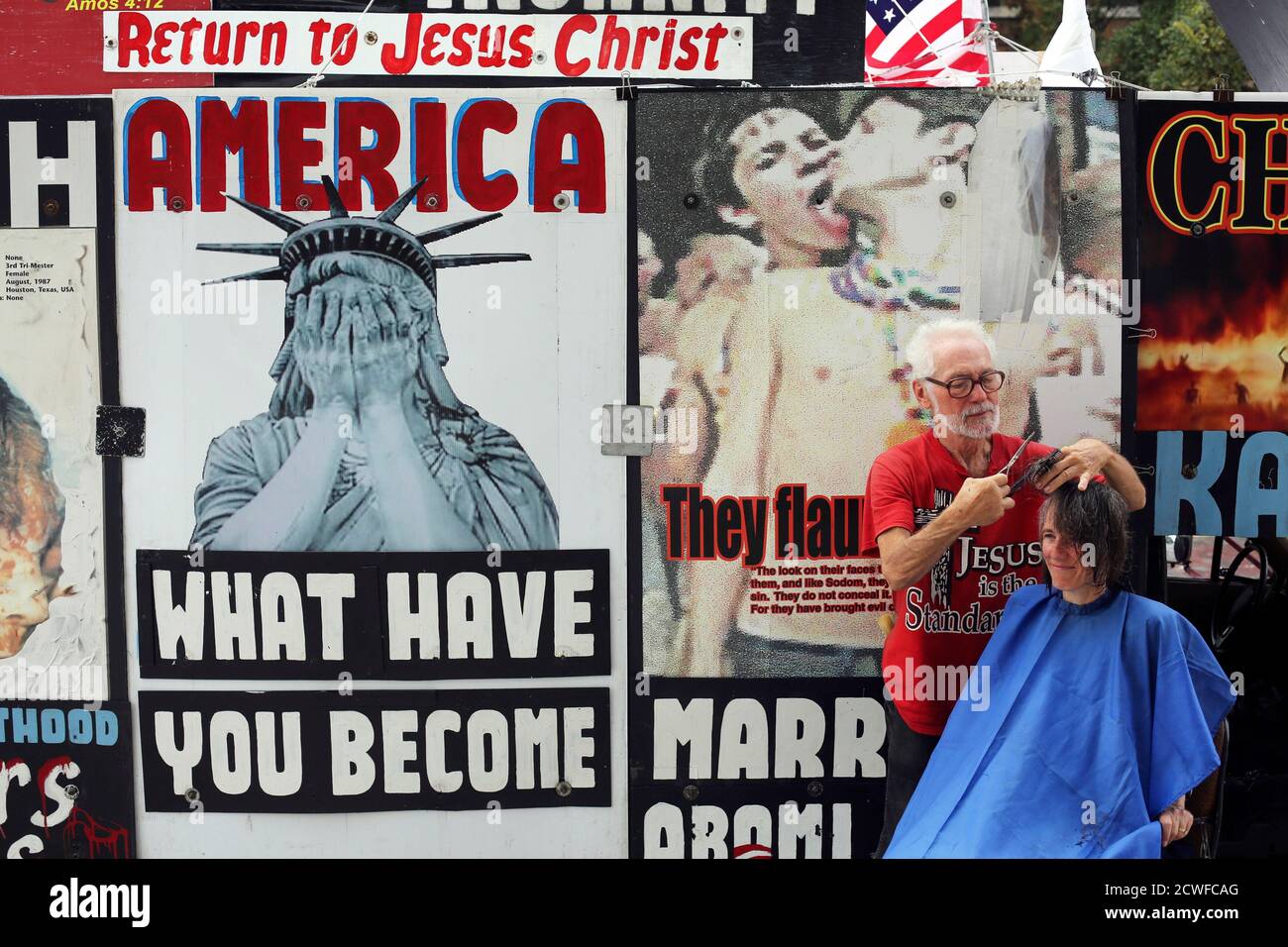 Ron Brock cuts Jeanne Kee's hair in front of his truck, covered in anti-abortion posters, outside of the Republican National Convention in Tampa, Florida on August 29, 2012.  REUTERS/Philip Andrews  (UNITED STATES - Tags: POLITICS ELECTIONS CIVIL UNREST TPX IMAGES OF THE DAY) Stock Photo