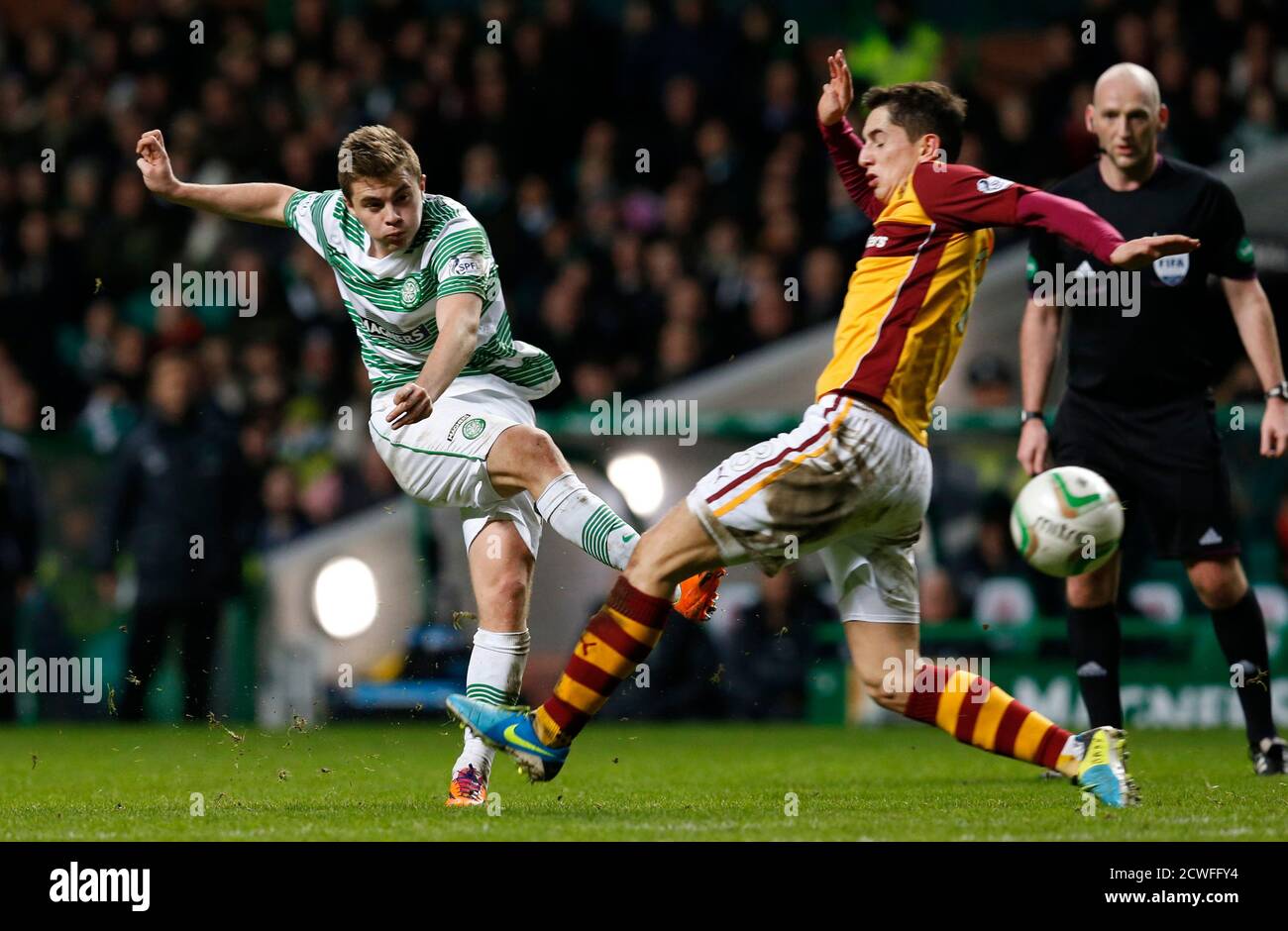 Celtic's James Forrest (L) is challenged by Motherwell's Stewart Carswell during their Scottish Premier League soccer match at Celtic Park, Glasgow, Scotland January 18, 2014. REUTERS/Russell Cheyne (BRITAIN - Tags: SPORT SOCCER) Stock Photo