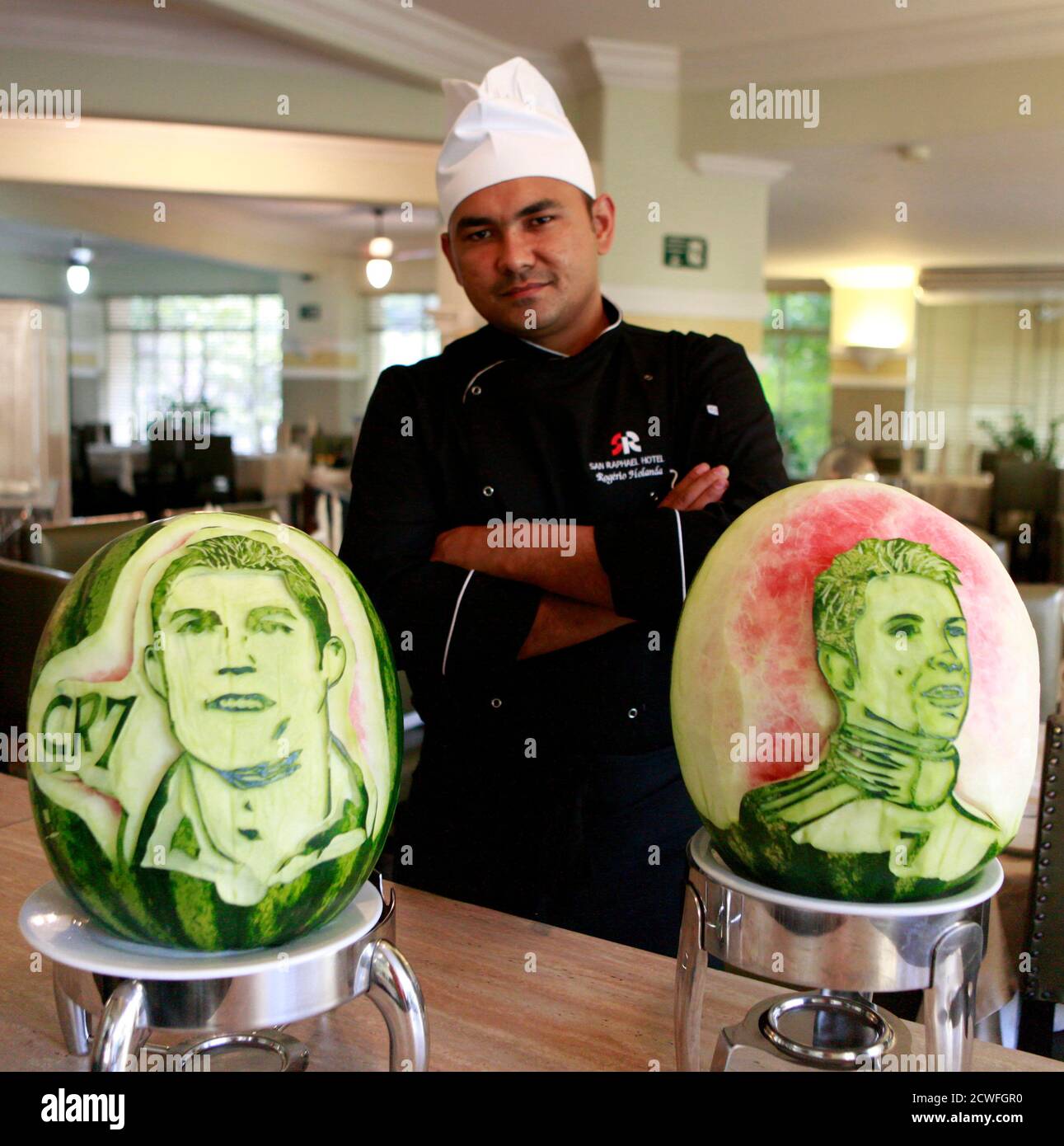 Chef Rogerio Holanda poses with carvings of Portugal's soccer player Cristiano Ronaldo which he made in watermelons at San Raphael hotel in Sao Paulo May 7, 2014. The 2014 World Cup will be held in Brazil from June 12 to July 13. REUTERS/Paulo Whitaker (BRAZIL - Tags: SPORT SOCCER WORLD CUP FOOD SOCIETY) Stock Photo