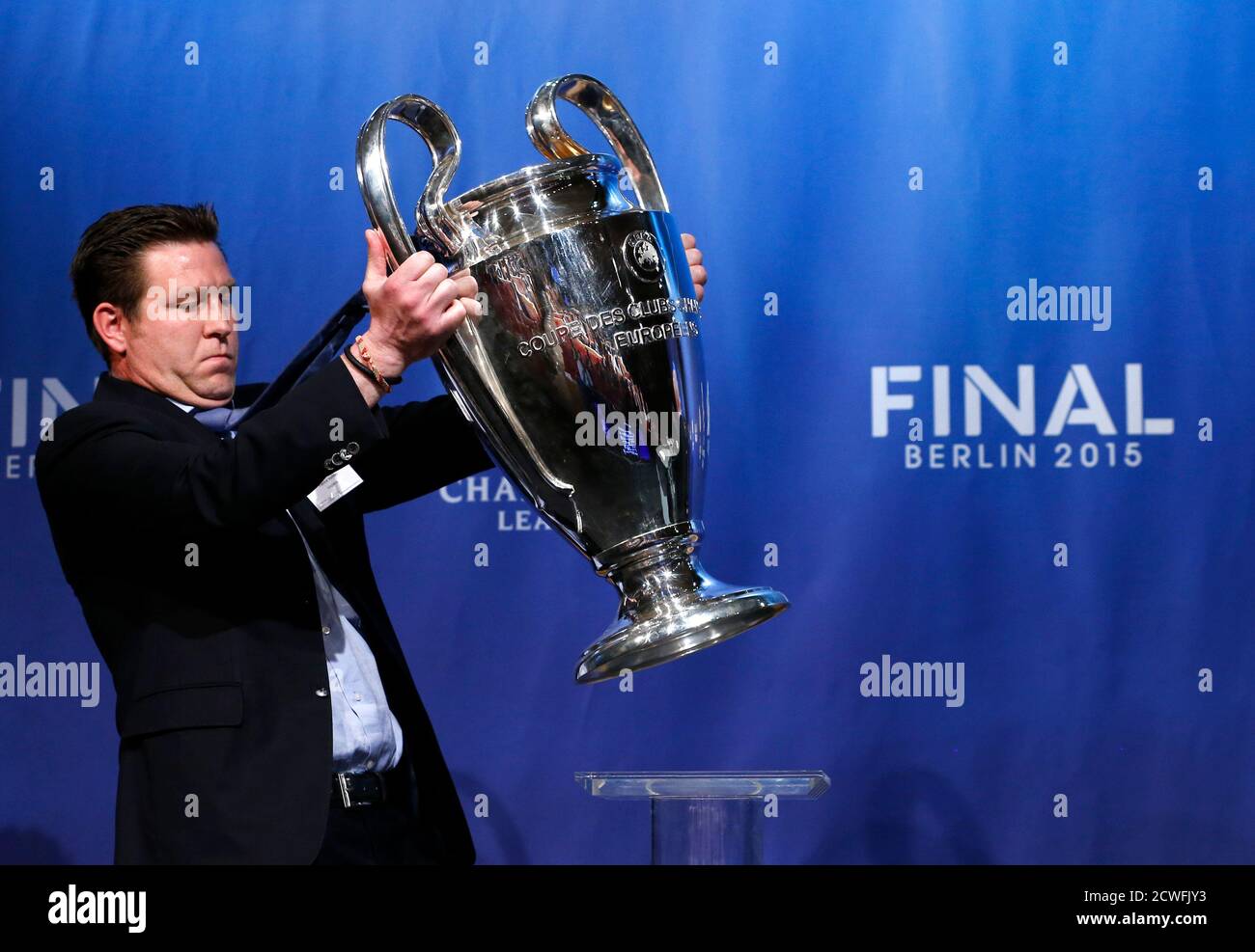 A UEFA member of staff brings in the Champions League soccer trophy before  the draw for the semi-finals matches at the UEFA headquarters in Nyon,  Switzerland, April 24, 2015. Barcelona will play