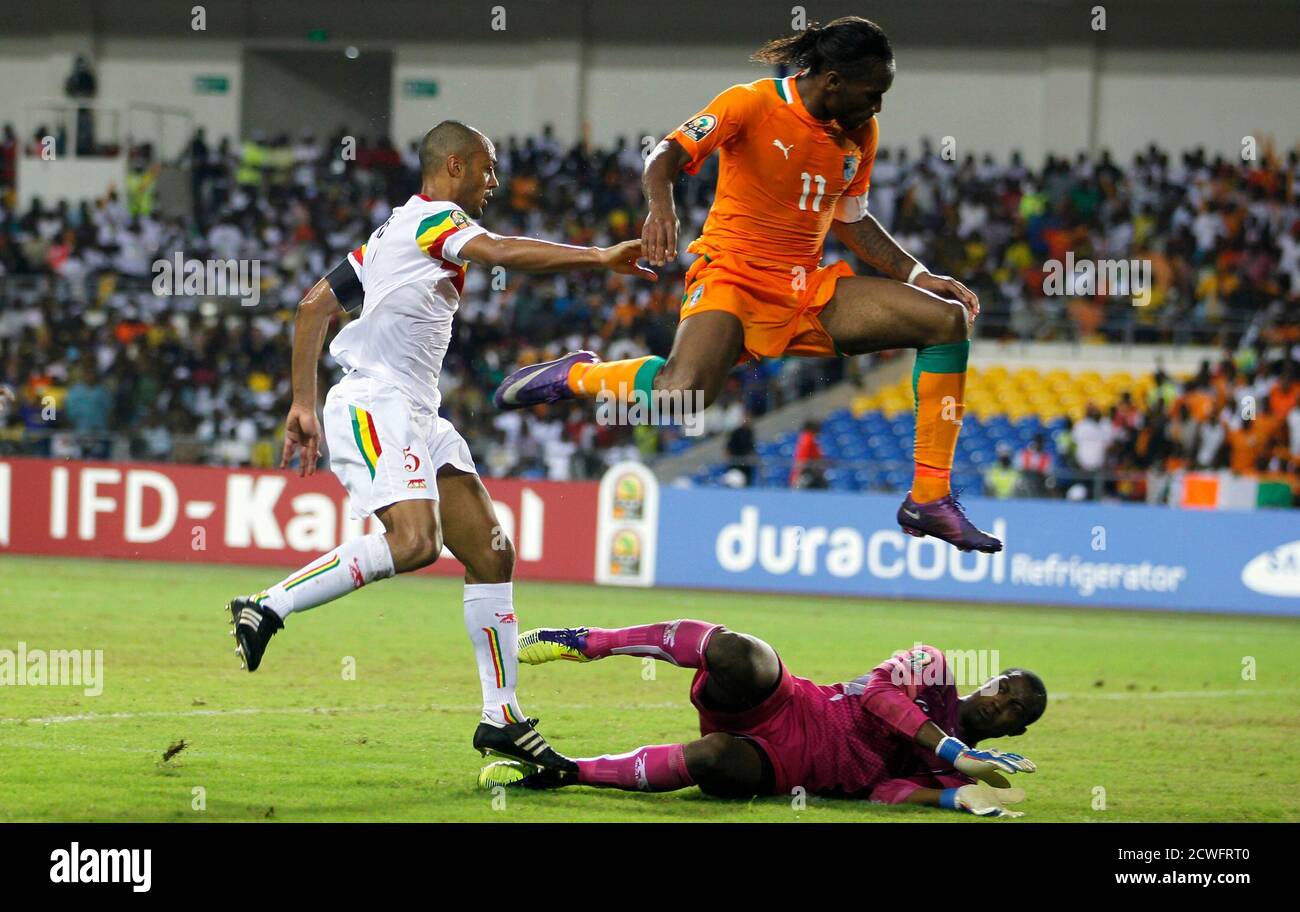 Ivory Coast's Didier Drogba (orange) jumps over Mali's goalkeeper Drissa Diakite during their African Nations Cup semi-final soccer match at the Stade De L'Amitie Stadium in Gabon's capital Libreville February 8, 2012. REUTERS/Thomas Mukoya (GABON - Tags: SPORT SOCCER TPX IMAGES OF THE DAY) Stock Photo