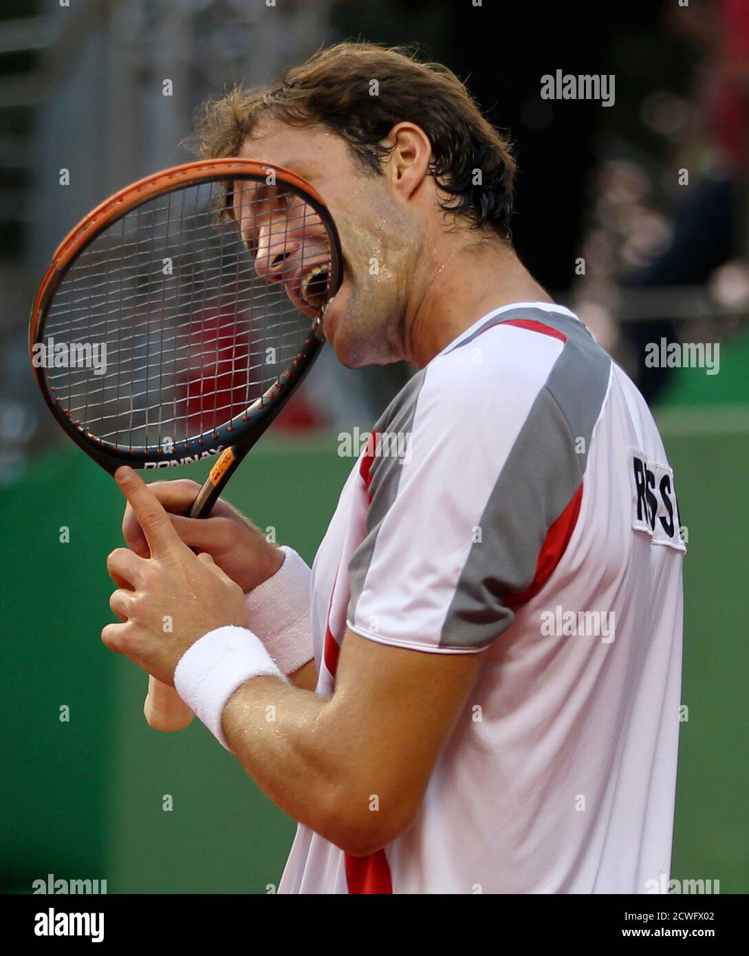 Teymuraz Gabashvil Of Russia Bites His Racket During His Davis Cup World Group Play Off Against Thomas Bellucci Of Brazil In Sao Jose Do Rio Preto September 14 12 Reuters Paulo Whitaker Brazil