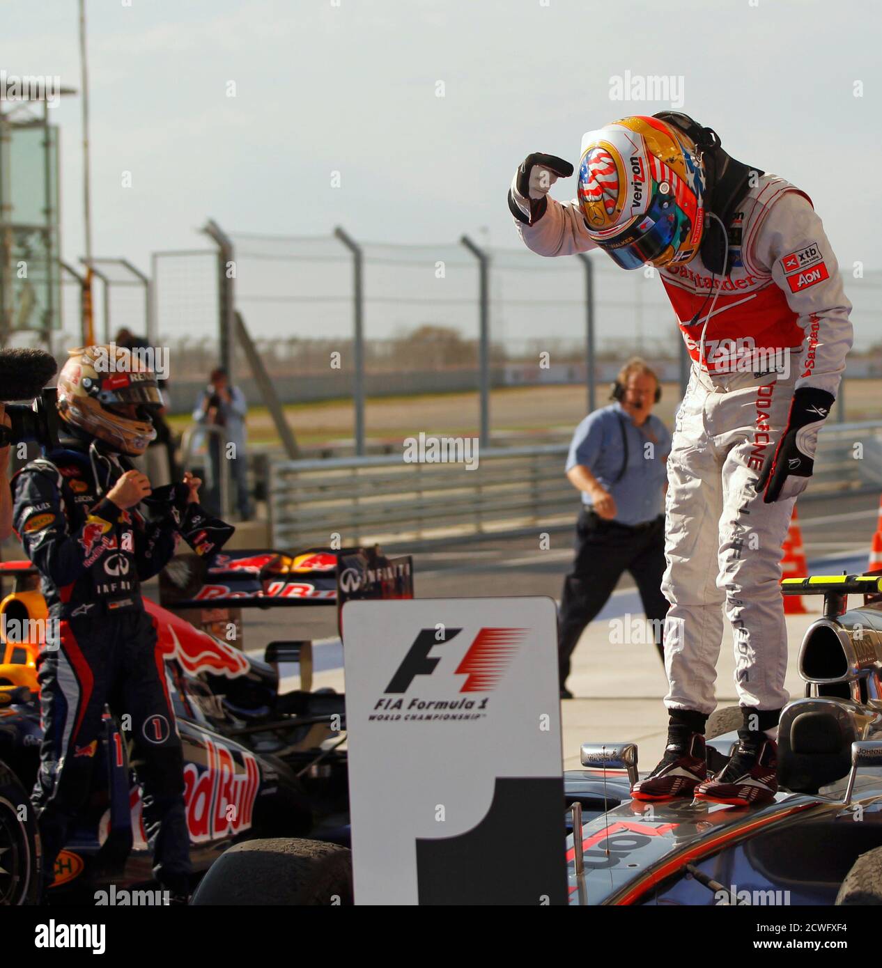 Mclaren Formula One Driver Lewis Hamilton R Of Britain Points To A U S Flag On His Helmet While Standing On His Car After Winning The U S F1 Grand Prix At The Circuit