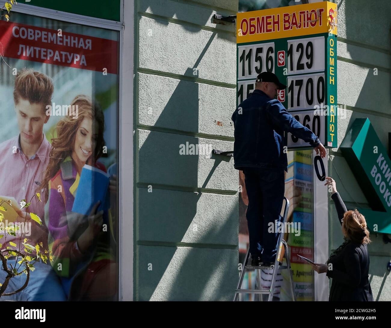 Exchange office workers change numbers indicating the conversion rates