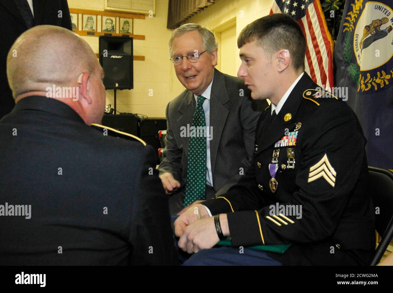 Senator Mitch McConnell (R-KY), (C), talks with Kentucky National Guard Sgt. Jesse Wethington (R) before presenting him with a Purple Heart at the VFW Post 1170 in Louisville, Kentucky, April 5, 2014. In their bid to unseat 'establishment' Republican incumbent senators this year the top priority for many in the conservative Tea Party movement is McConnell in Kentucky, but they face a tough campaigner who has been preparing to fend off a primary challenge since 2010.  Picture taken April 5, 2014.   REUTERS/John Sommers II  (UNITED STATES - Tags: POLITICS ELECTIONS) Stock Photo
