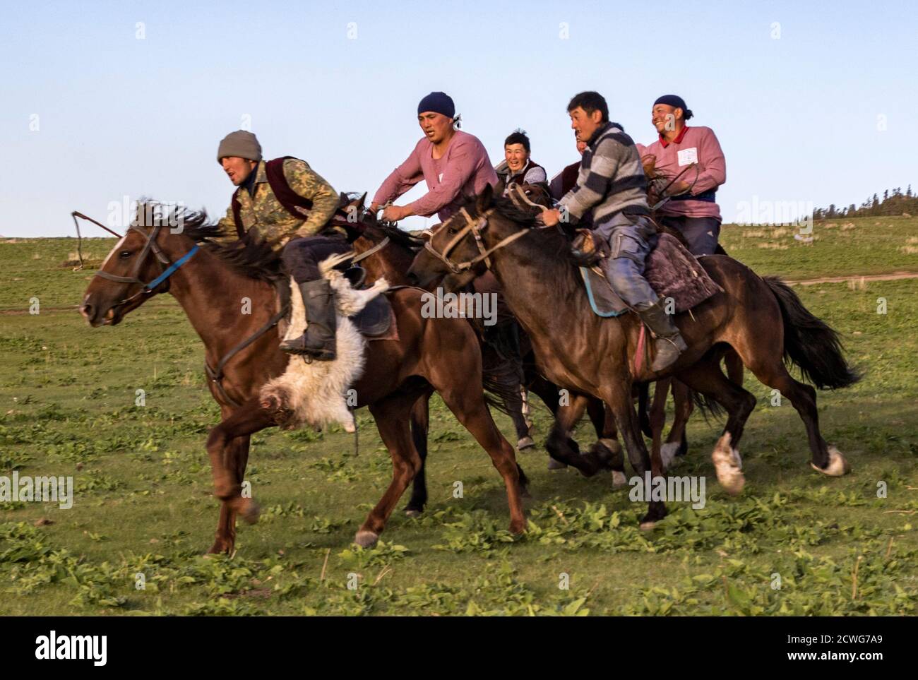 Issyk Kul, Kyrgyzstan - May 28, 2017 - Buzkashi players race towards the goal with their headless goat Stock Photo