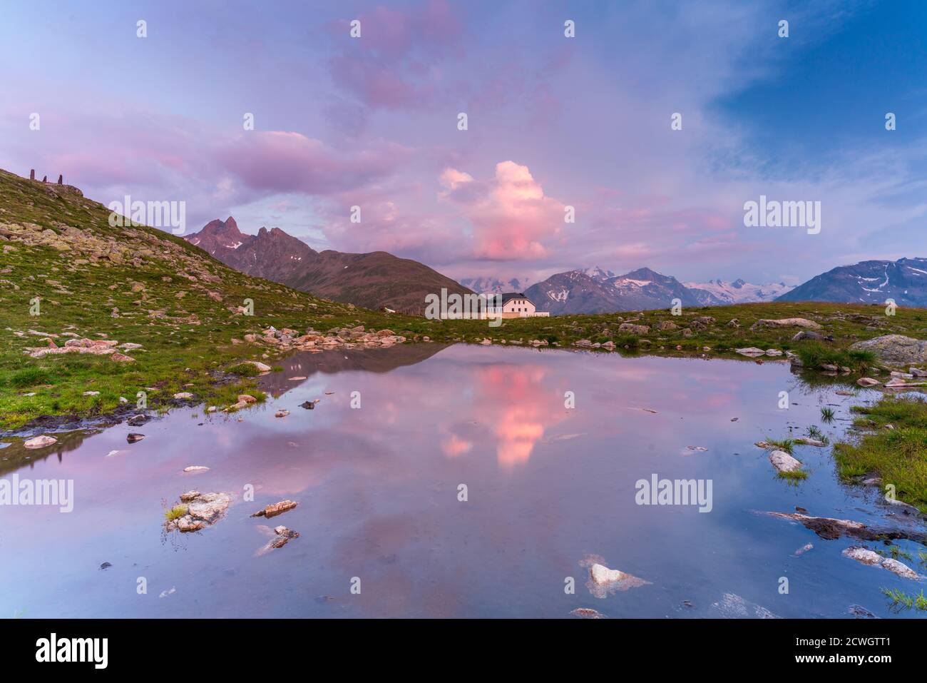 Pink sky at sunset over the small alpine lake, Muottas Muragl, Samedan, canton of Graubunden, Engadine, Switzerland Stock Photo