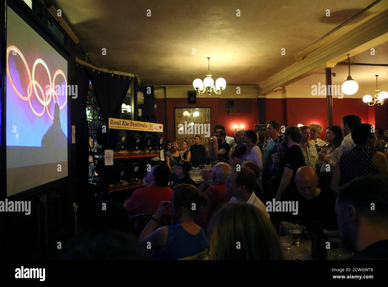 People watch the opening ceremony of the London 2012 Olympic Games at a pub in London July 27, 2012.  REUTERS/Sergio Moraes (BRITAIN - Tags: SPORT OLYMPICS SOCIETY) Stock Photo
