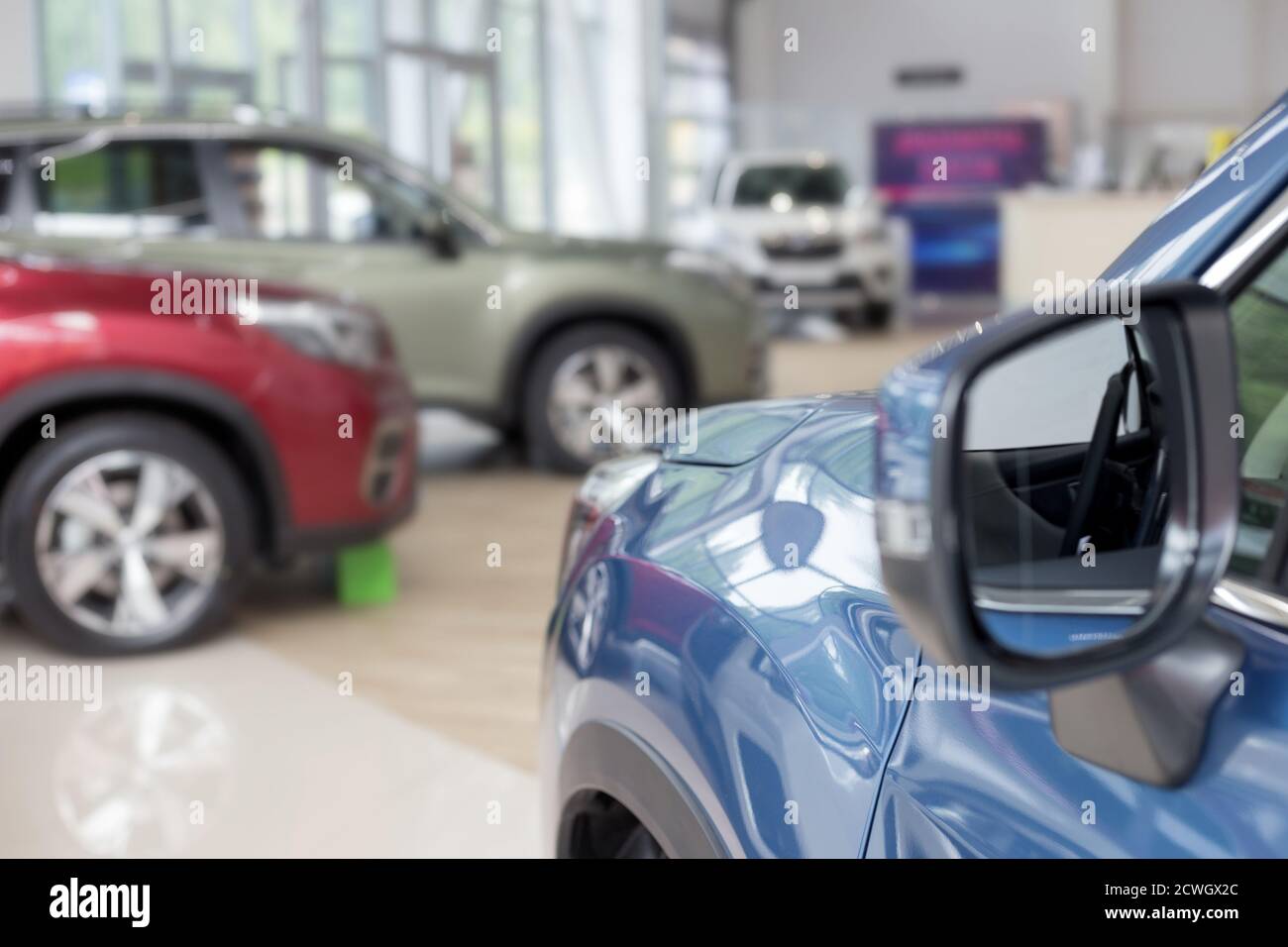 New cars at dealer showroom. Themed blur background with bokeh effect. Car auto dealership. Prestigious vehicles. Stock Photo