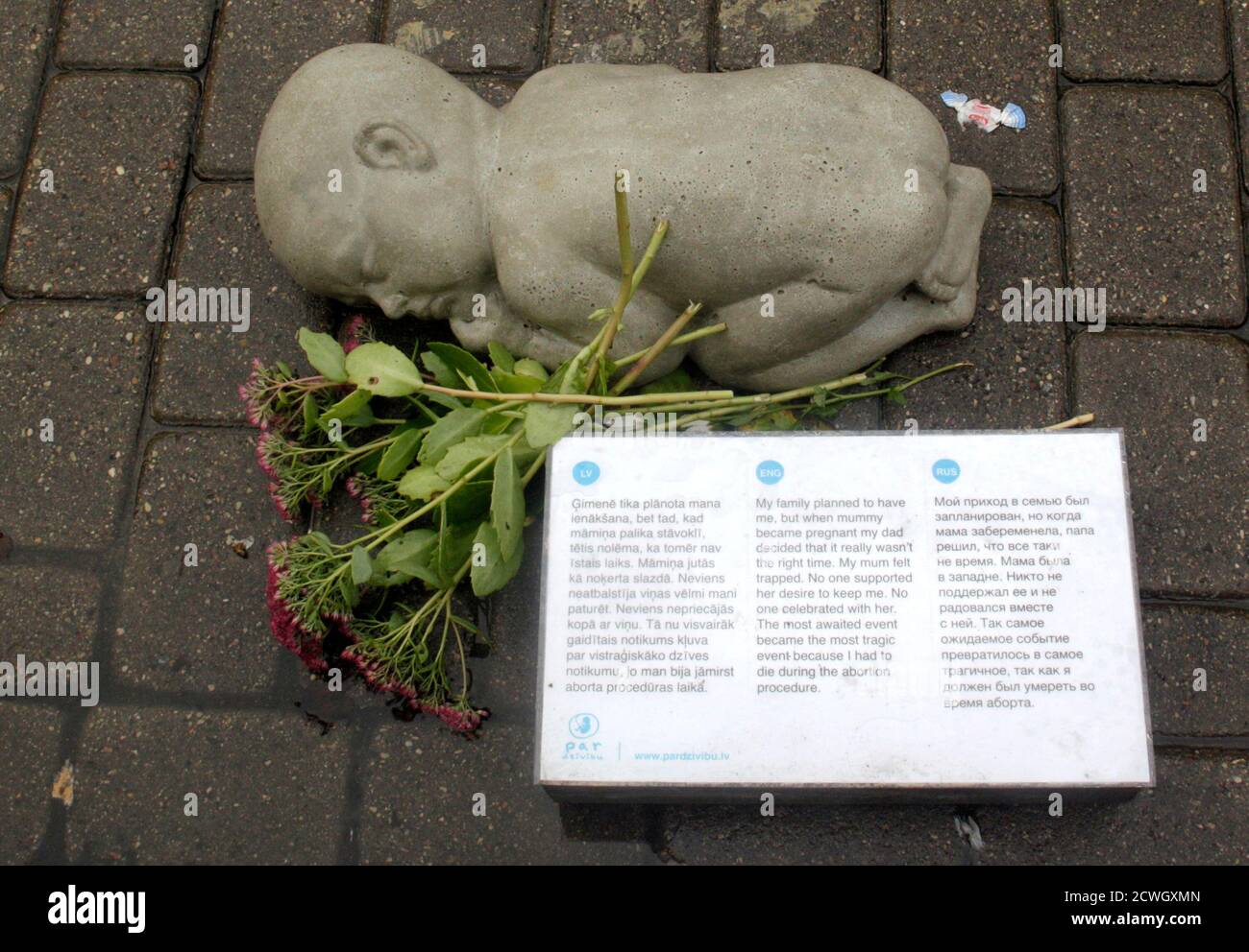 A sculpture and flowers are displayed during an anti-abortion campaign on the street in Riga October 11, 2012. Several non-governmental organisations and conservative politicians started an anti-abortion campaign to solve a problem of the Latvia's aging society, according to local media. REUTERS/Ints Kalnins (LATVIA - Tags: HEALTH SOCIETY) Stock Photo
