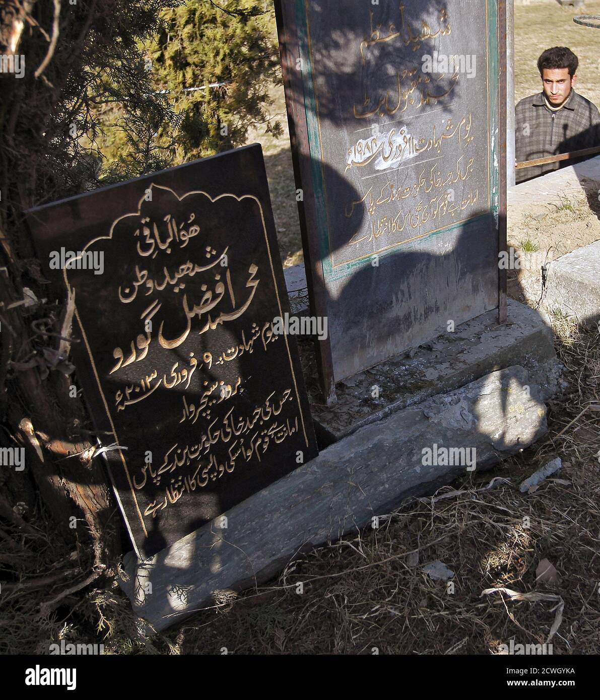 An epitaph (L) for Mohammad Afzal Guru is seen at the Mazar-e-Shohda (Martyr's graveyard) in Srinagar February 12, 2013. India hanged Mohammad Afzal Guru, a Kashmiri man, on Saturday for an attack on the country's parliament in 2001, sparking clashes in Kashmir between protesters and police. Security forces had imposed a curfew in parts of Kashmir and ordered people off the streets. The writing on the epitaph reads: "Martyr of homeland Mohammad Afzal Guru, Martyrdom date February 9, 2013, whose mortal remains are lying with the government of India and the nations is waiting for its return". RE Stock Photo