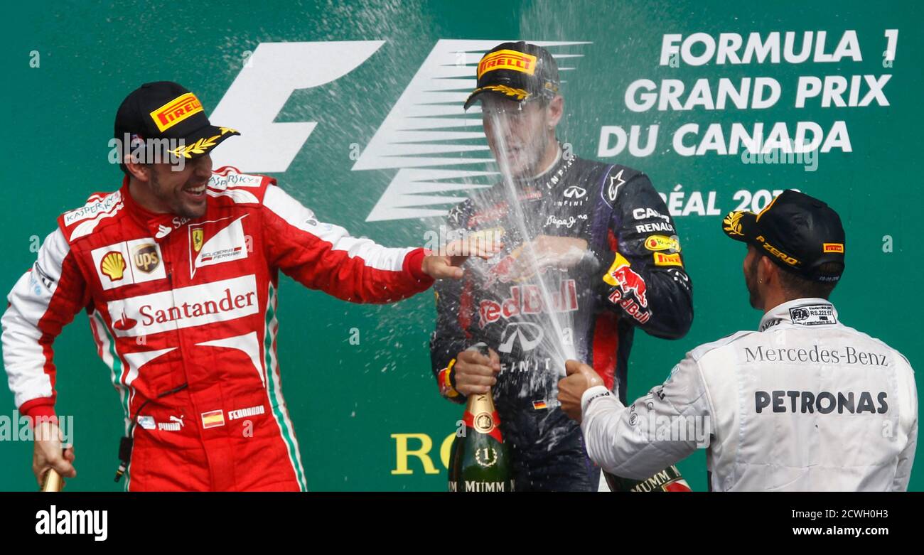 Third-placed Mercedes Formula One driver Lewis Hamilton (R) of Britain sprays champagne at first-placed Red Bull Formula One driver Sebastian Vettel of Germany after Vettel won the Canadian F1 Grand Prix at the Circuit Gilles Villeneuve in Montreal June 9, 2013. Standing at left is second-placed Ferrari Formula One driver Fernando Alonso of Spain. REUTERS/Chris Wattie (CANADA  - Tags: SPORT MOTORSPORT F1 TPX IMAGES OF THE DAY) Stock Photo