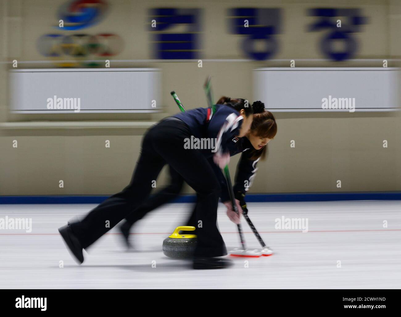 South Korean national curling team players Kim Ji-sun (L) and Gim Un-chi  bring the stone into the house during a training session at the Taereung  National Training Ceter in Seoul November 27,