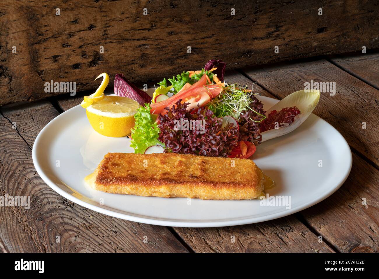 Dish with traditional Cotoletta fried meat with salad, Italy Stock Photo