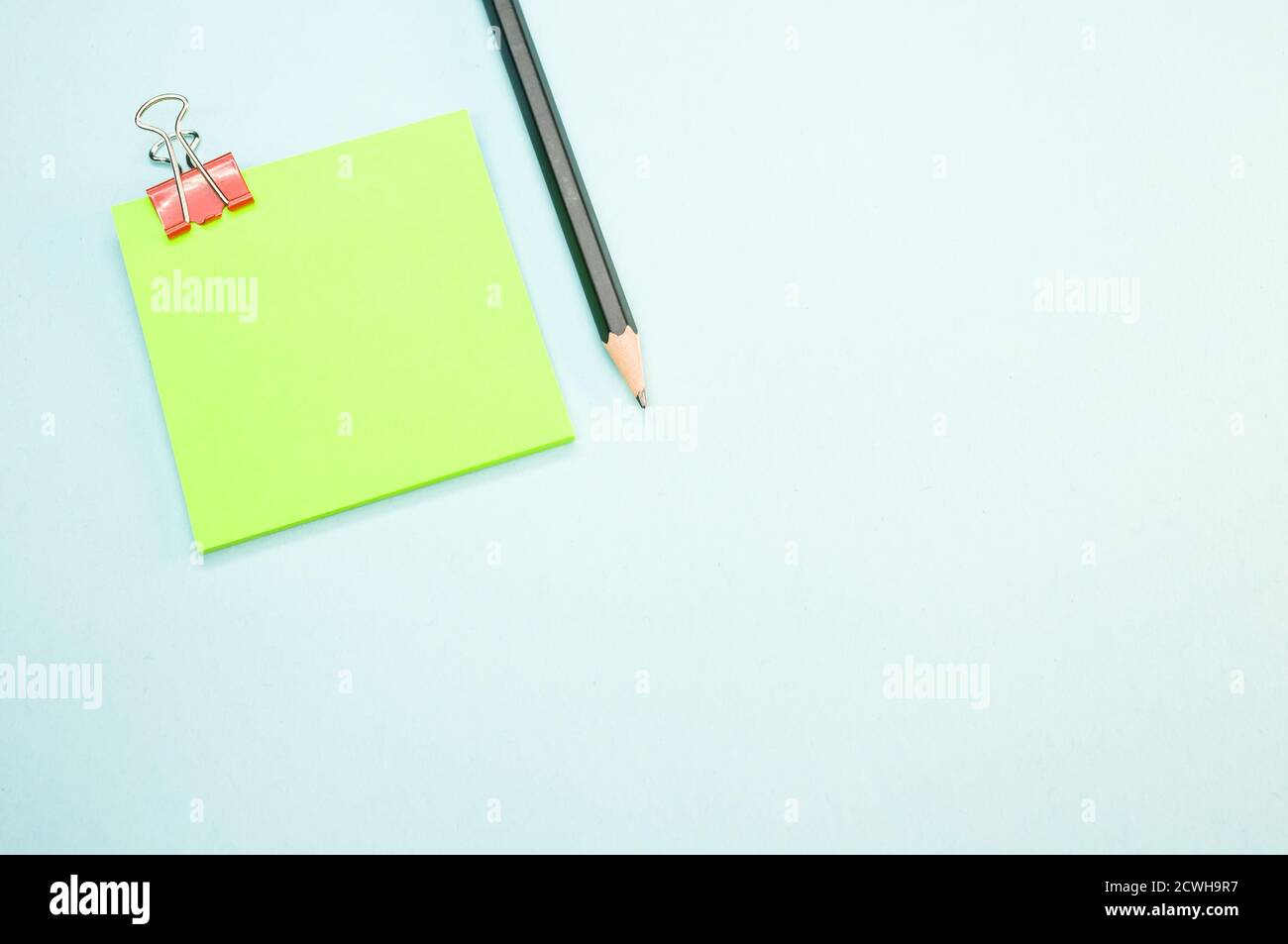 Closeup shot of the pencil and the notepad on the blue surface Stock Photo