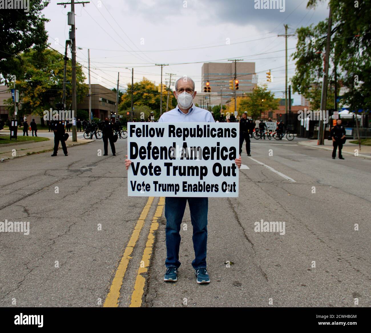 Cleveland, Ohio, USA. 29th Sep, 2020. As ex-VP Biden was due to drive by. This rally-goer with sign saying FELLOW REPUBLICANS DEFEND AMERICA VOTE TRUMP OUT - VOTE TRUMP ENABLERS OUT, had planned on being at the Lagoon where BLM protestors were gathering, but couldn't until the police re-opened the street. He said he had been working up the nerve to come ot protest. Police were blocking the intersections near Case Western Reserve University, in preparation for President Trump and former Vice President Biden's motorcades drive to the Medical Center where they would clash a few hours later in Stock Photo