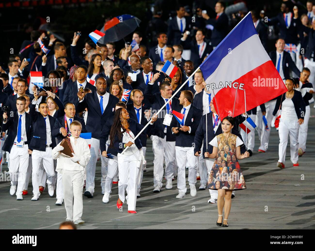 France's flag bearer Laura Flessel-Colovic holds the national flag as she  leads the contingent in the athletes parade during the opening ceremony of  the London 2012 Olympic Games at the Olympic Stadium