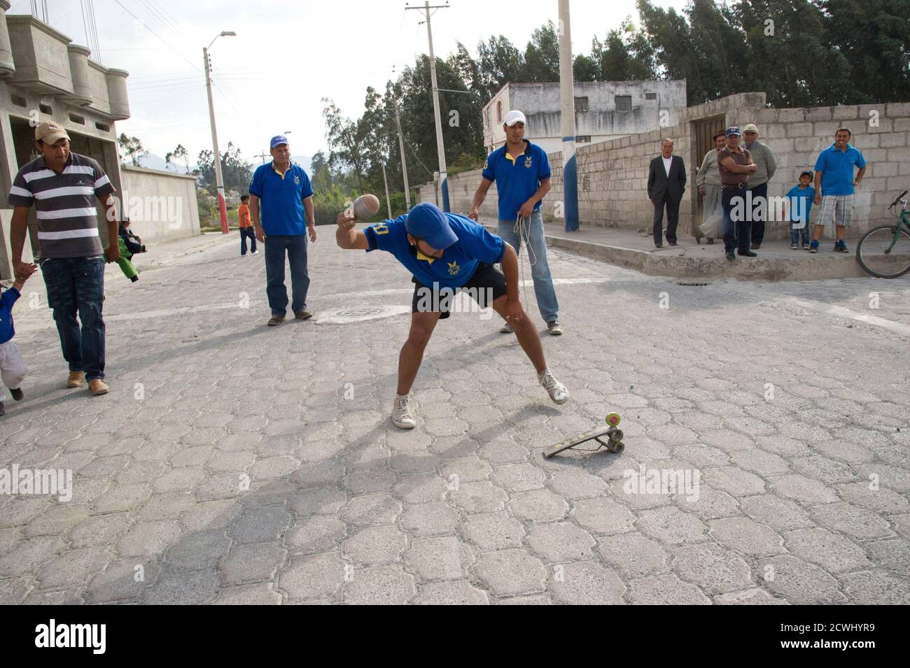 A resident hits his "trompo gigante" to play a "cave" during a game of "trompo gigante" in Cotacachi, about 120 km (75 miles) north of Quito September 8, 2012. Fifteen teams, each made up of 10 members, representing different neighbourhoods of the village compete to see who can hit "la bola" from the start point in the main park to the finishing point about 8-10 km (5-6.2 miles) away through the streets of Cotacachi with the least number of "caves", or hits. The game, an annual event, runs from August to November and was started in the village famous for its leather 17 years ago. The contestan Stock Photo
