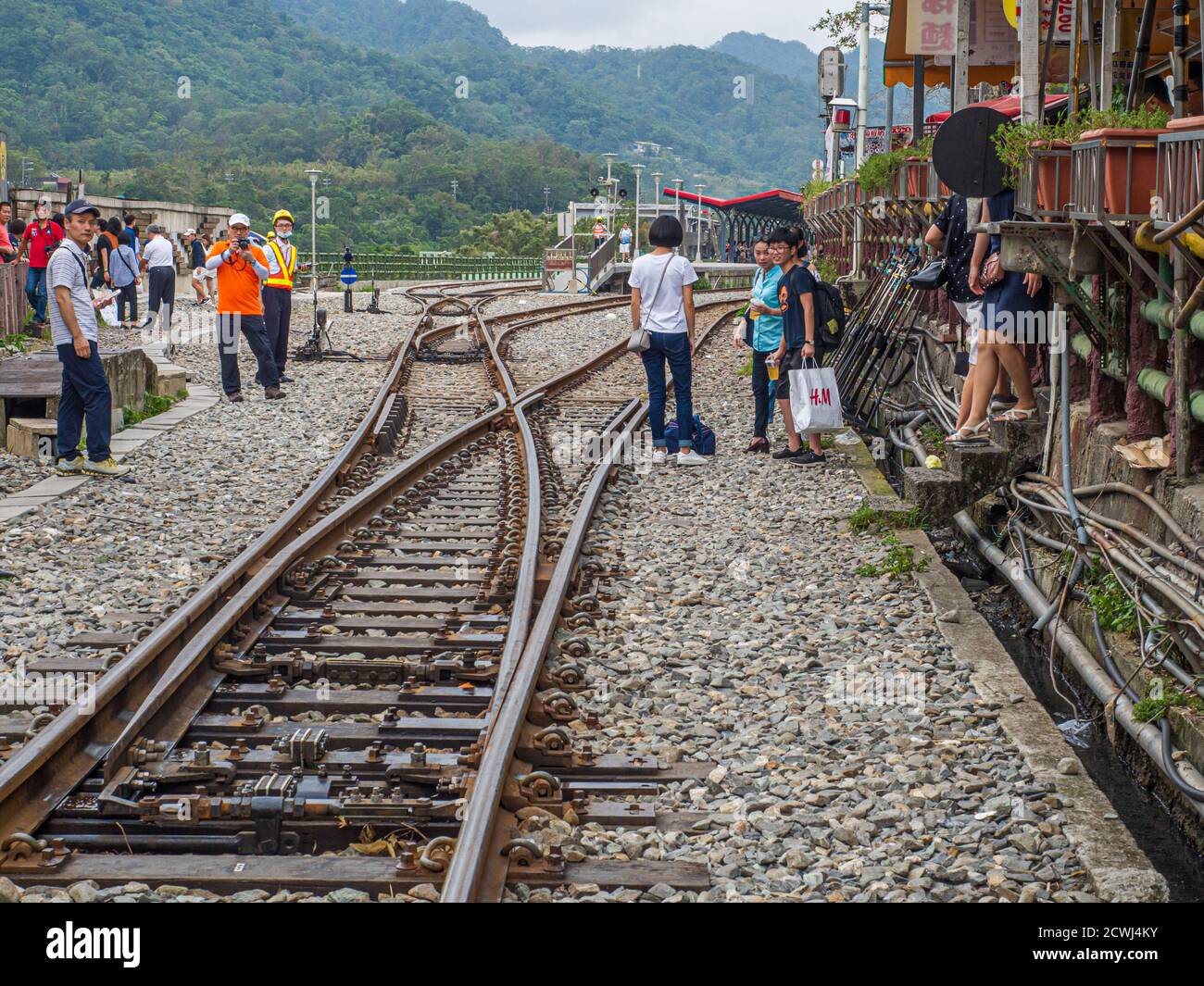 Shifen, Taiwan - October 05, 2016: Many people  on the railroad tracks  very close to buildings. Asia Stock Photo