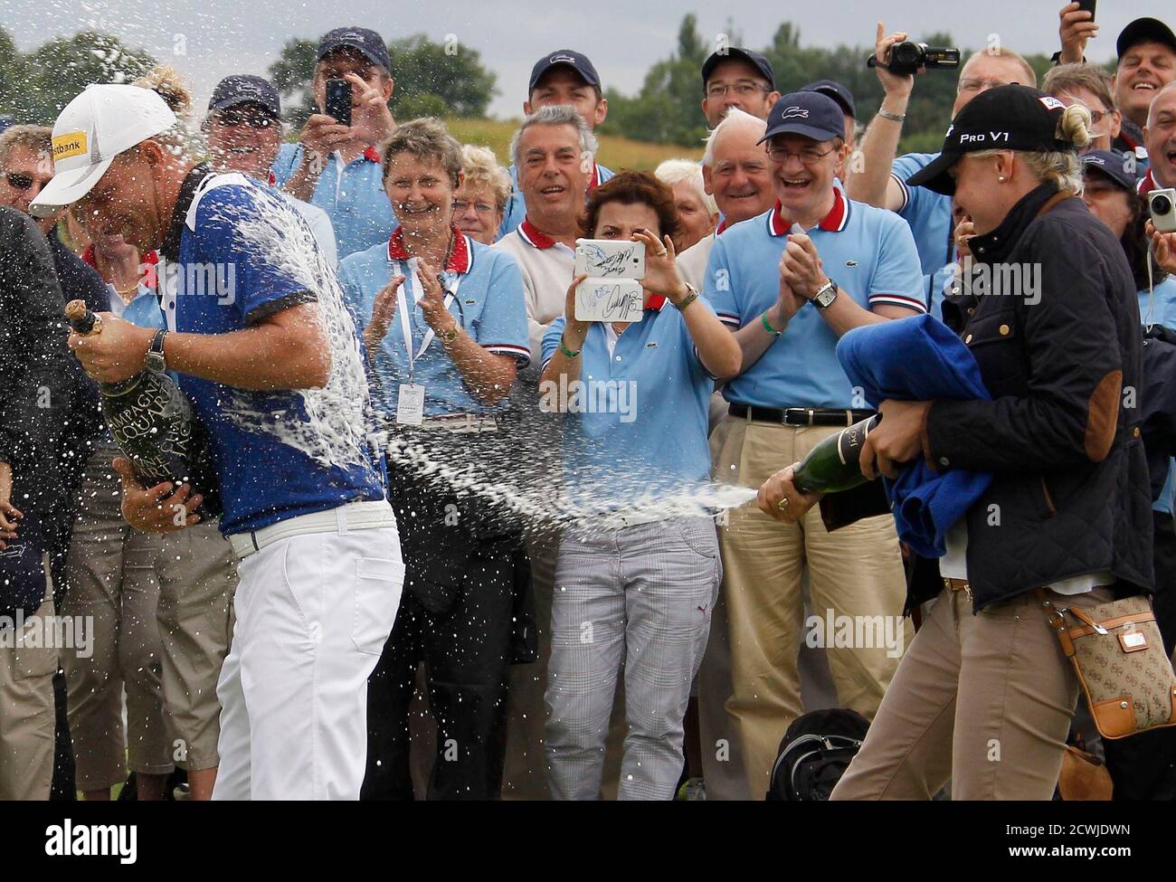 Germany's Marcel Siem (L) is sprayed with champagne by his girlfriend Laura  Polak as they celebrate him winning the French Open golf tournament at the  Golf National course in Saint-Quentin-en-Yvelines, near Paris